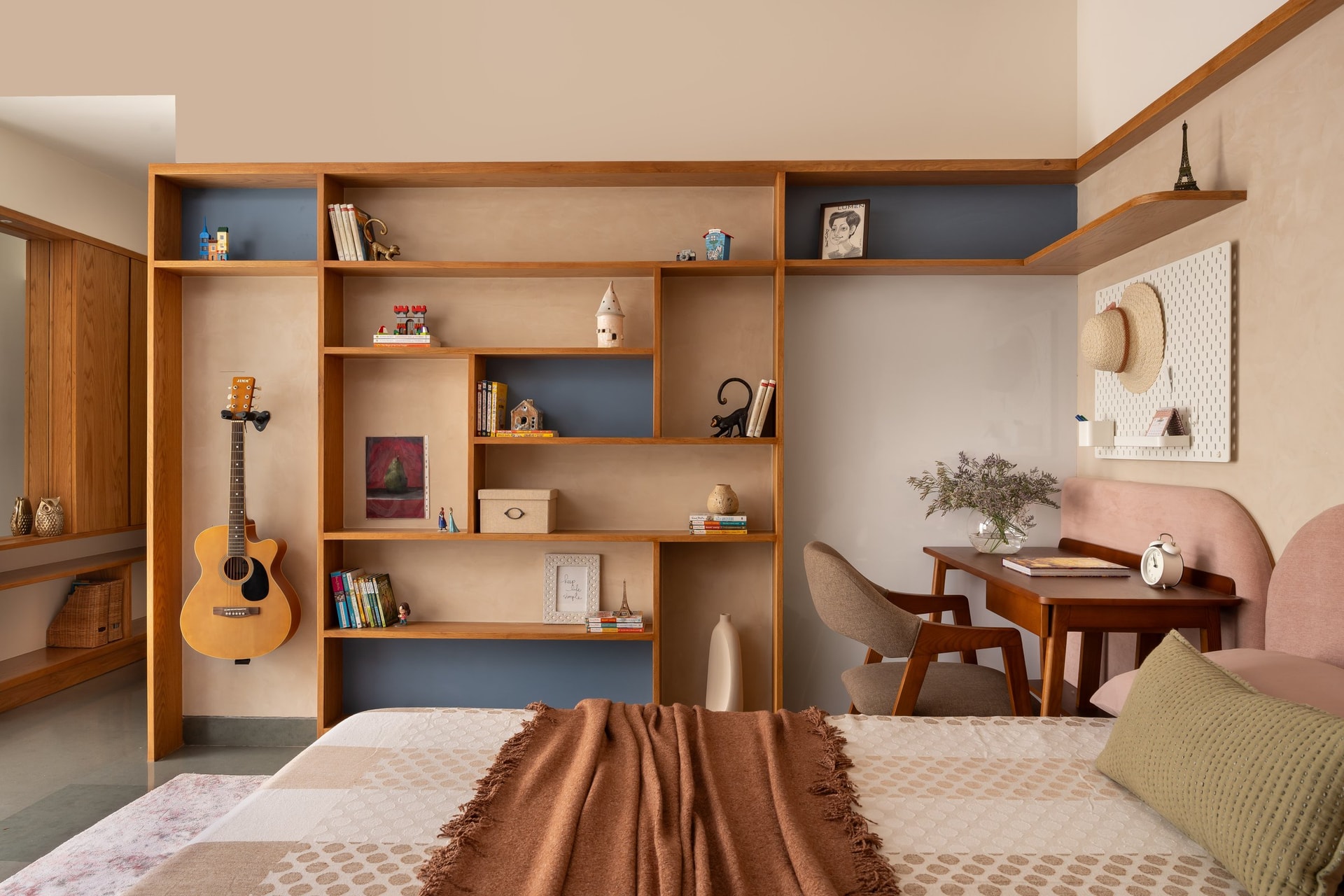 The kids' bedroom shelving wall, where a guitar on a wall-mount and blue back panels transform storage into the room's primary character