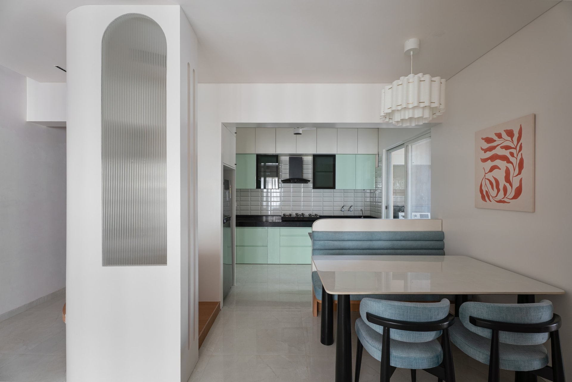 Mint-green kitchen cabinetry and the fluted-glass partition seen from the dining side
