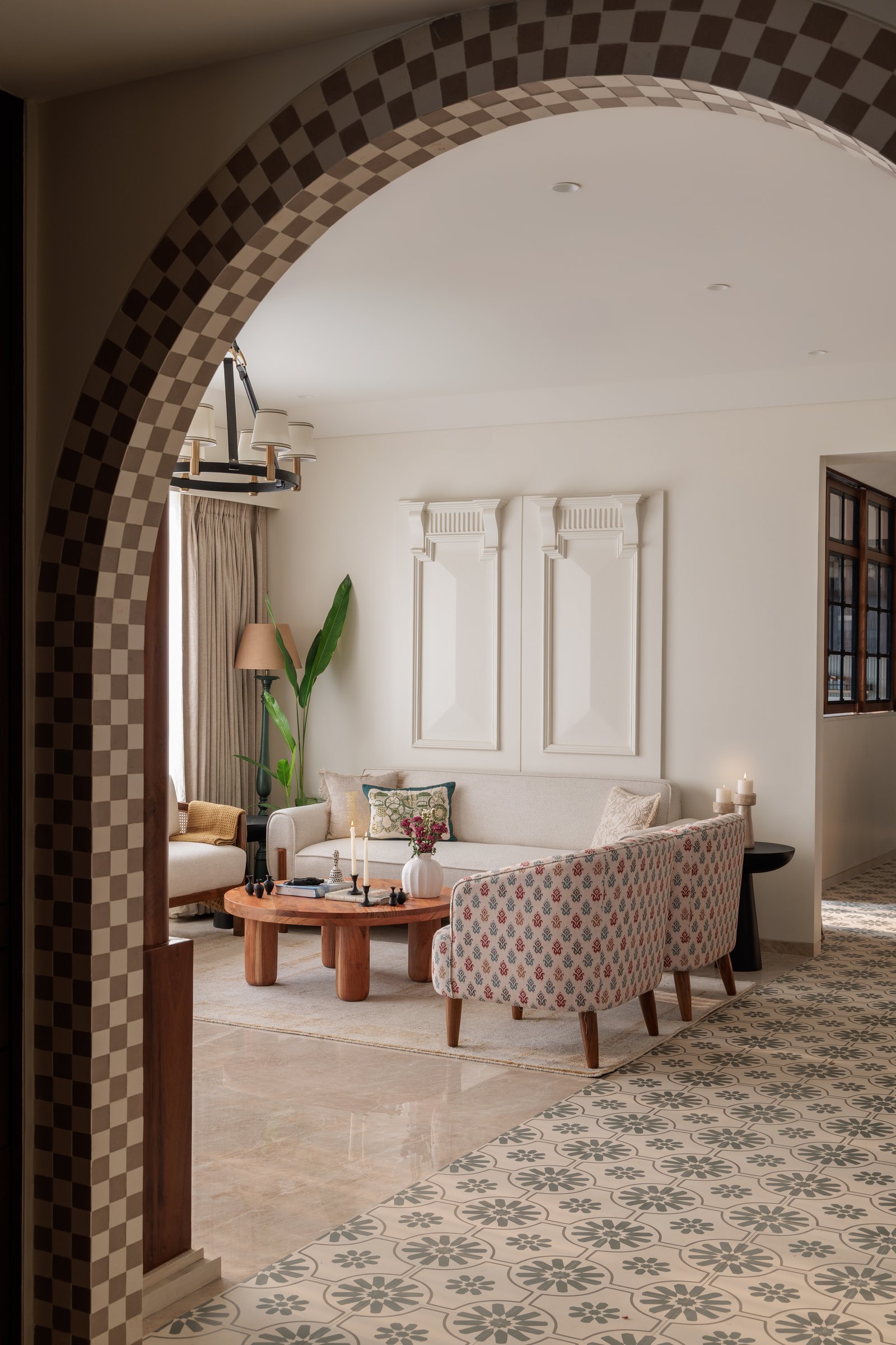 The living room framed through the checkered arch, the home's most distinctive architectural gesture