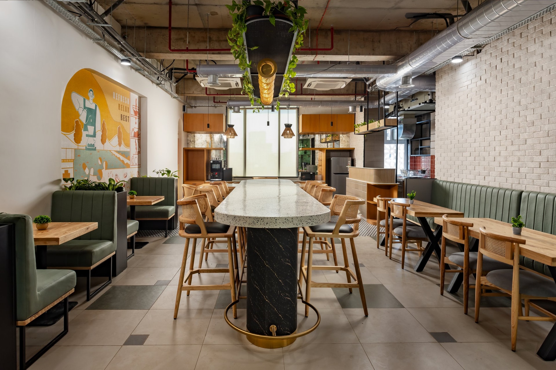 The cafeteria, anchored by a terrazzo communal table and softened by olive banquettes and cane chairs