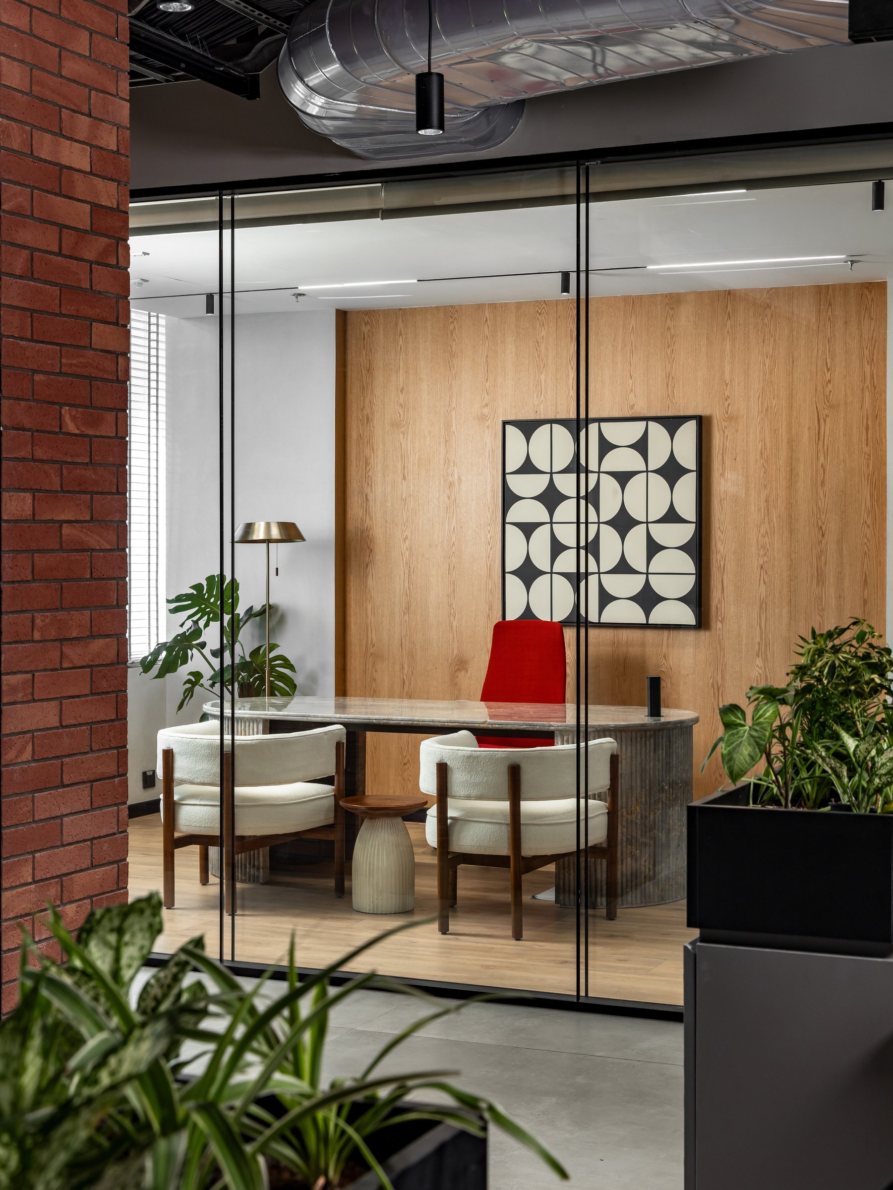 The leadership cabin: a curved fluted desk meets a panelled wood wall in a quietly midcentury register