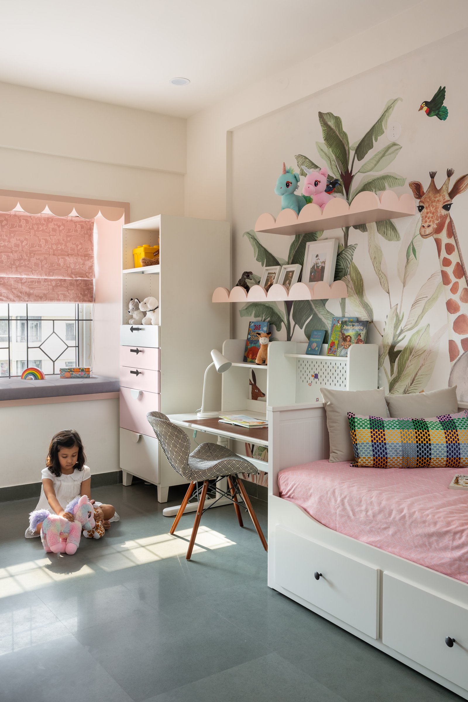 The daughter's room, with its hand-painted jungle mural, scalloped pink shelves and dusty-rose window seat