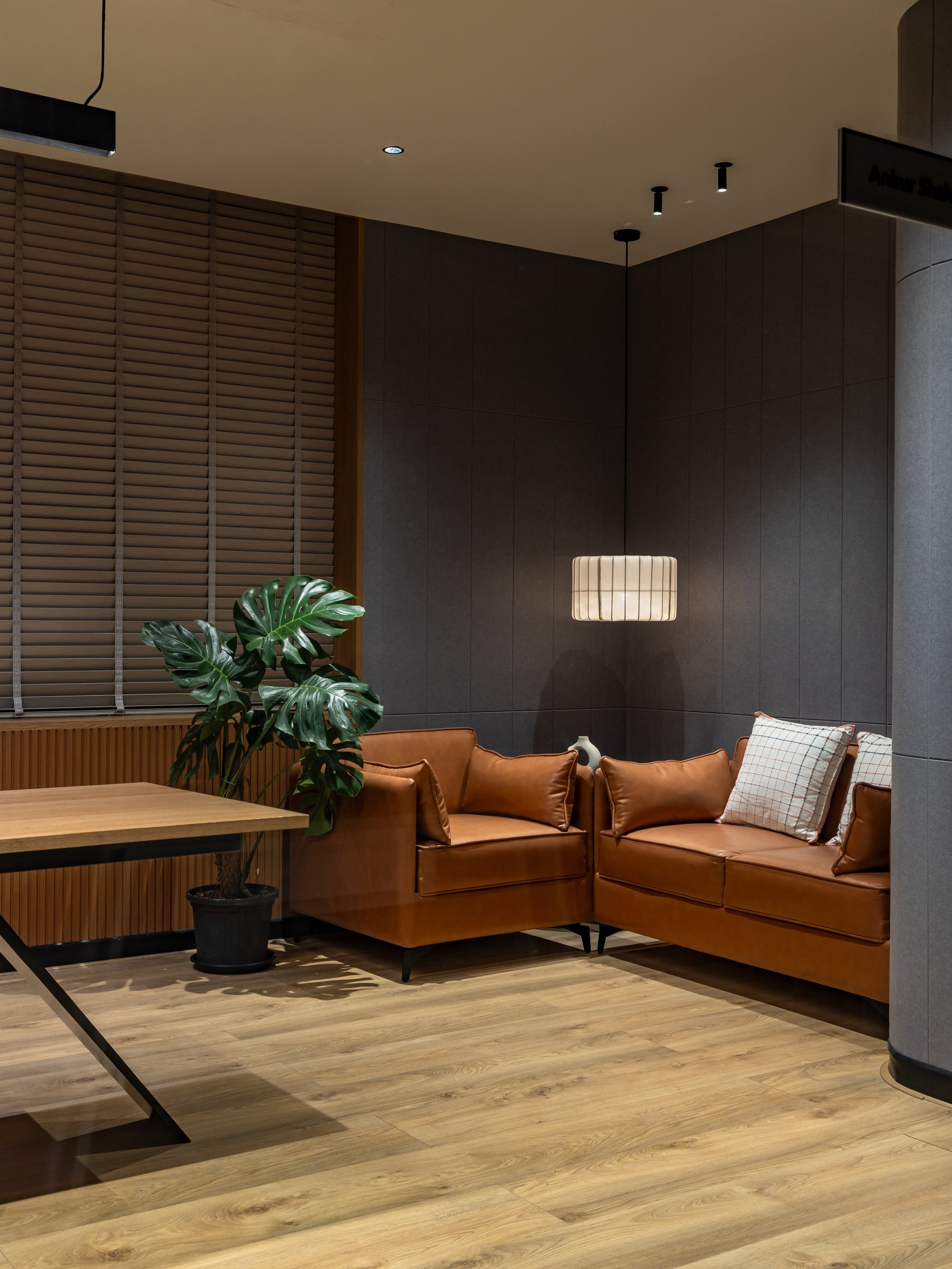 Within the same cabin, an upholstered seating corner sized for the conversations that happen off the desk