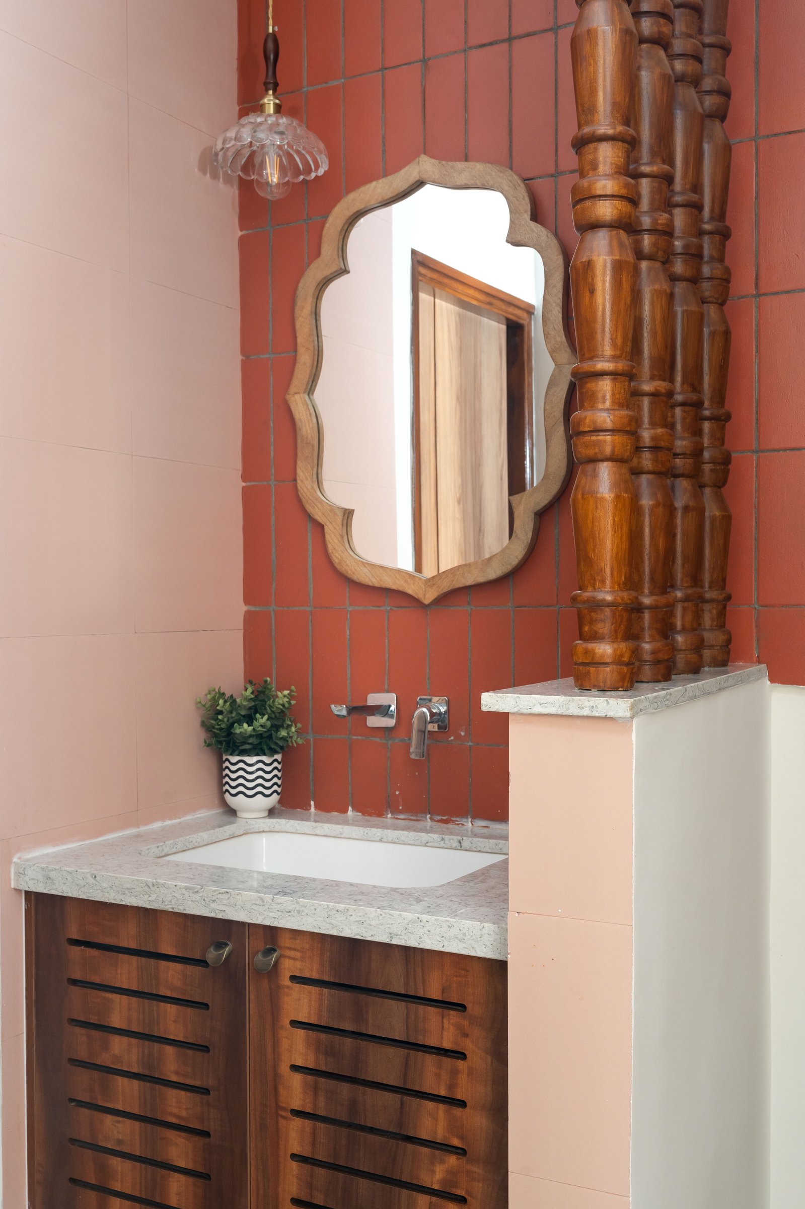 The powder room, where stacked terracotta tile and a scalloped wooden mirror borrow quietly from temple architecture