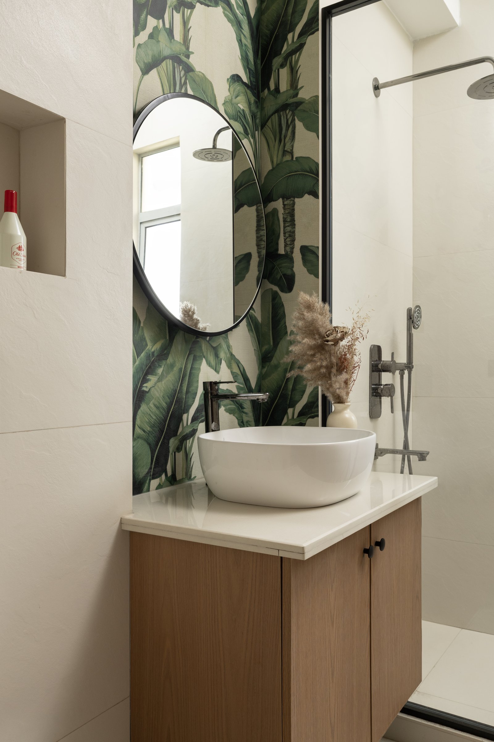 The bathroom: a single saturated banana-leaf wall, contained and confident