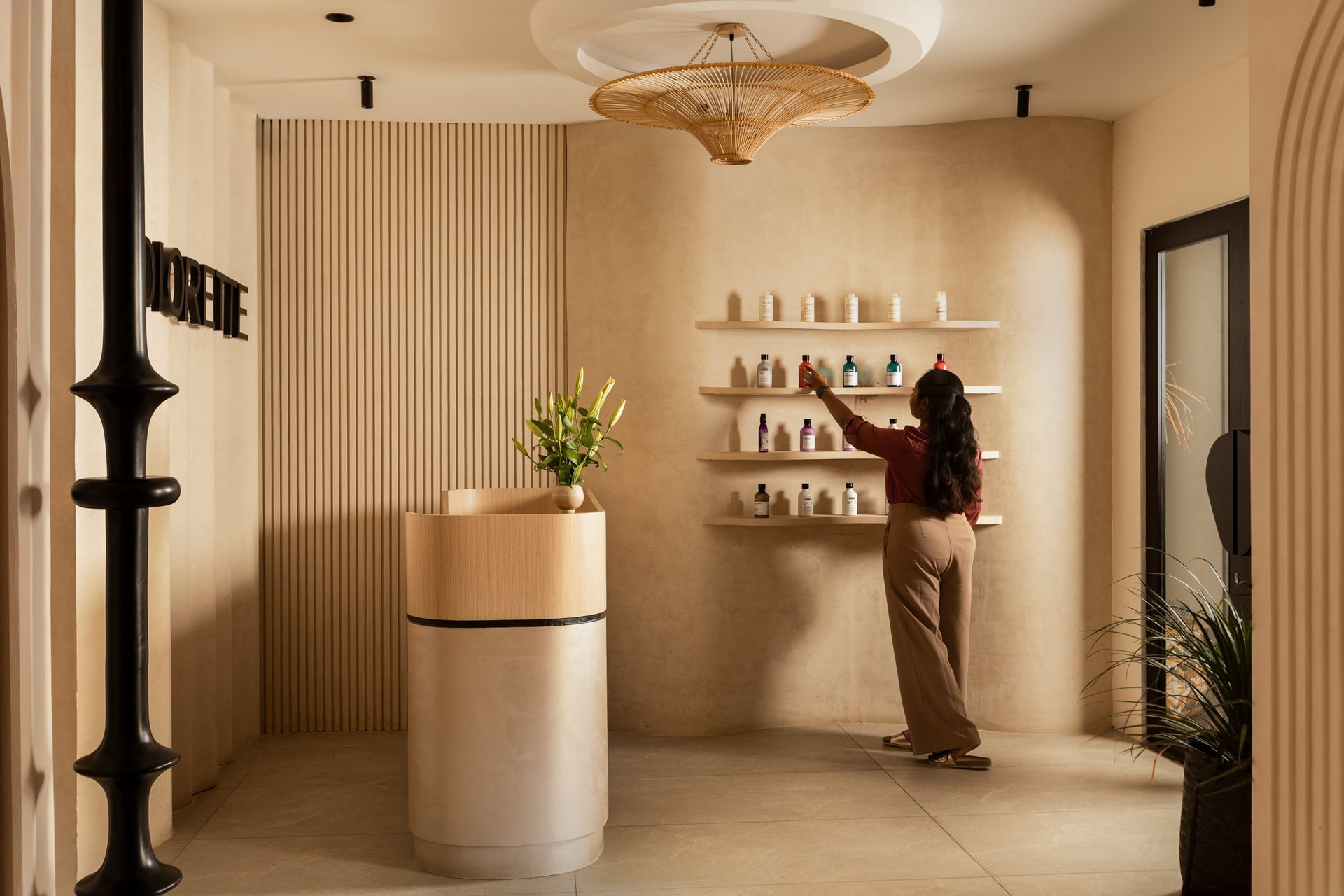 The retail wall, where floating shelves and a rattan pendant turn product display into composition
