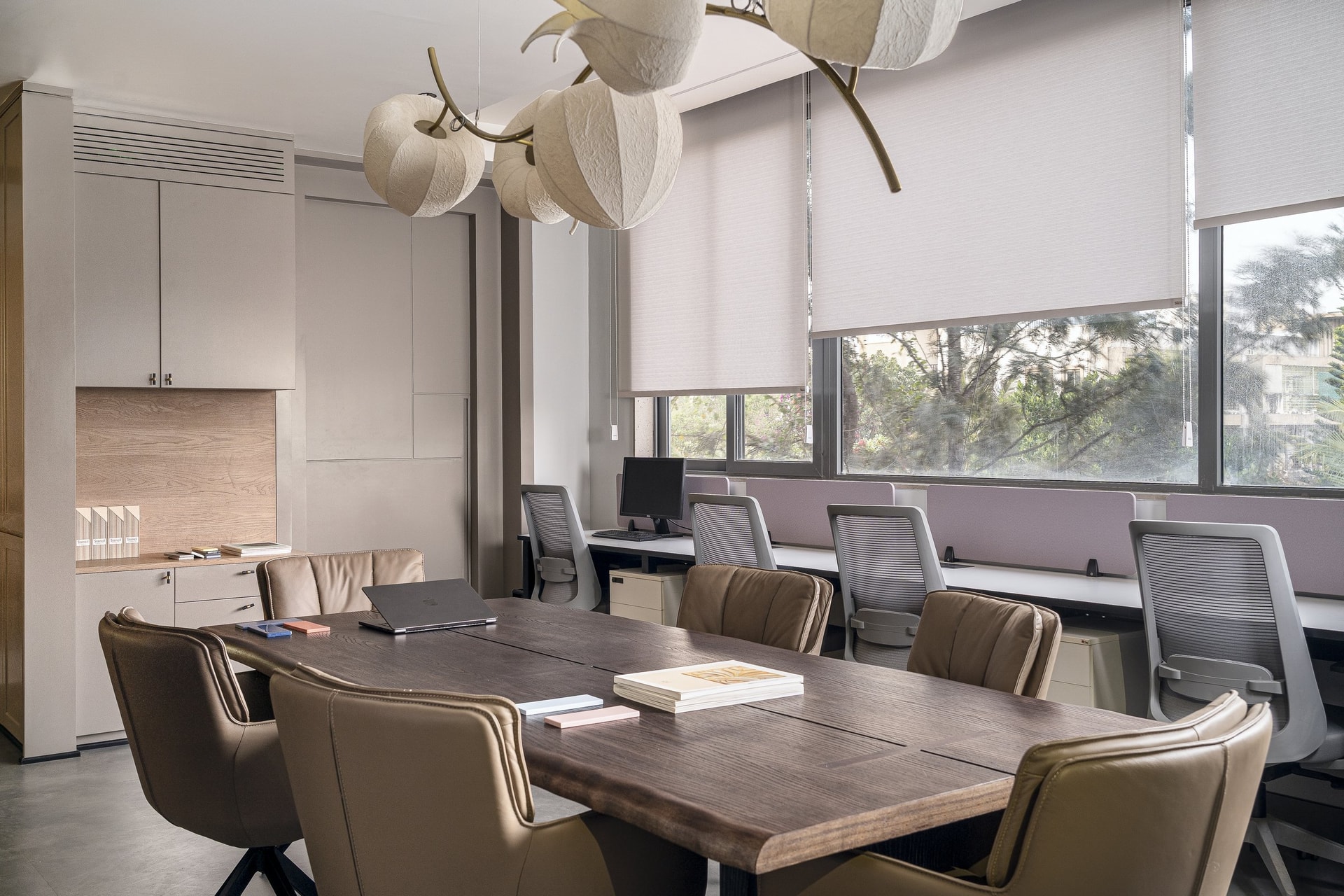 The same room recomposed: built-in greige storage, a fluted wooden inset, and roller blinds softening the daylight
