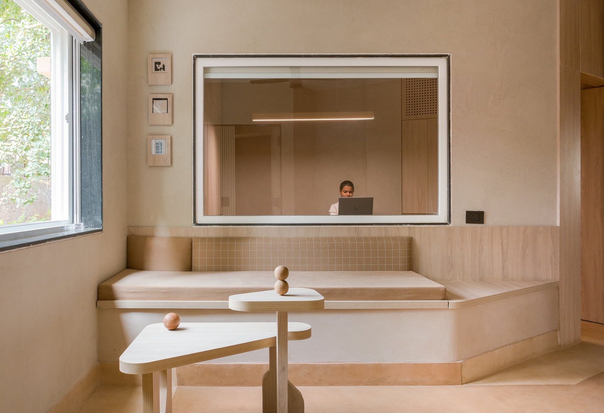 An internal window frames the workstation beyond, treating the partition as a curatorial device