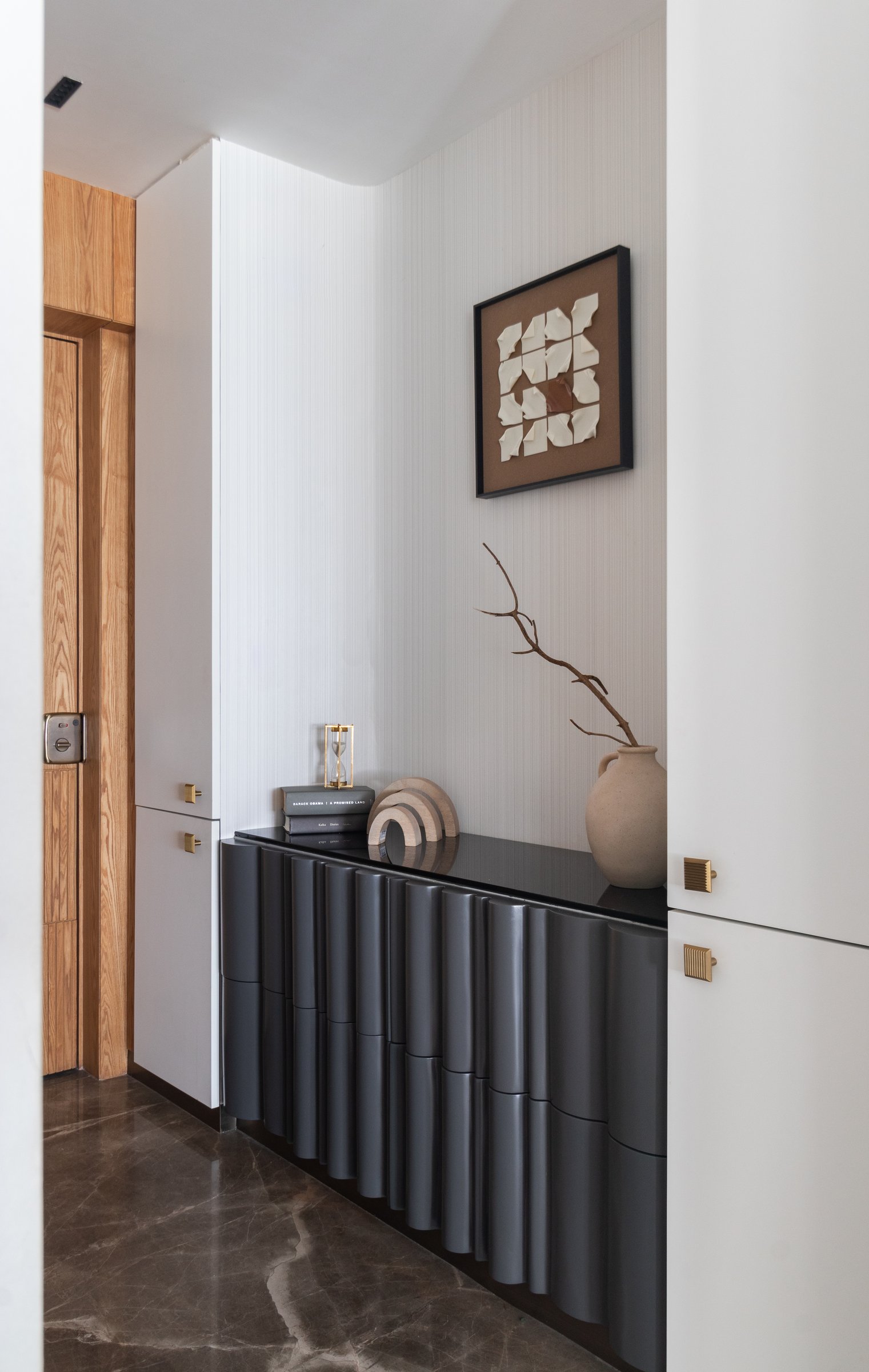 The foyer, where a grey fluted console and a weathered branch in a terracotta vessel set the home's material grammar