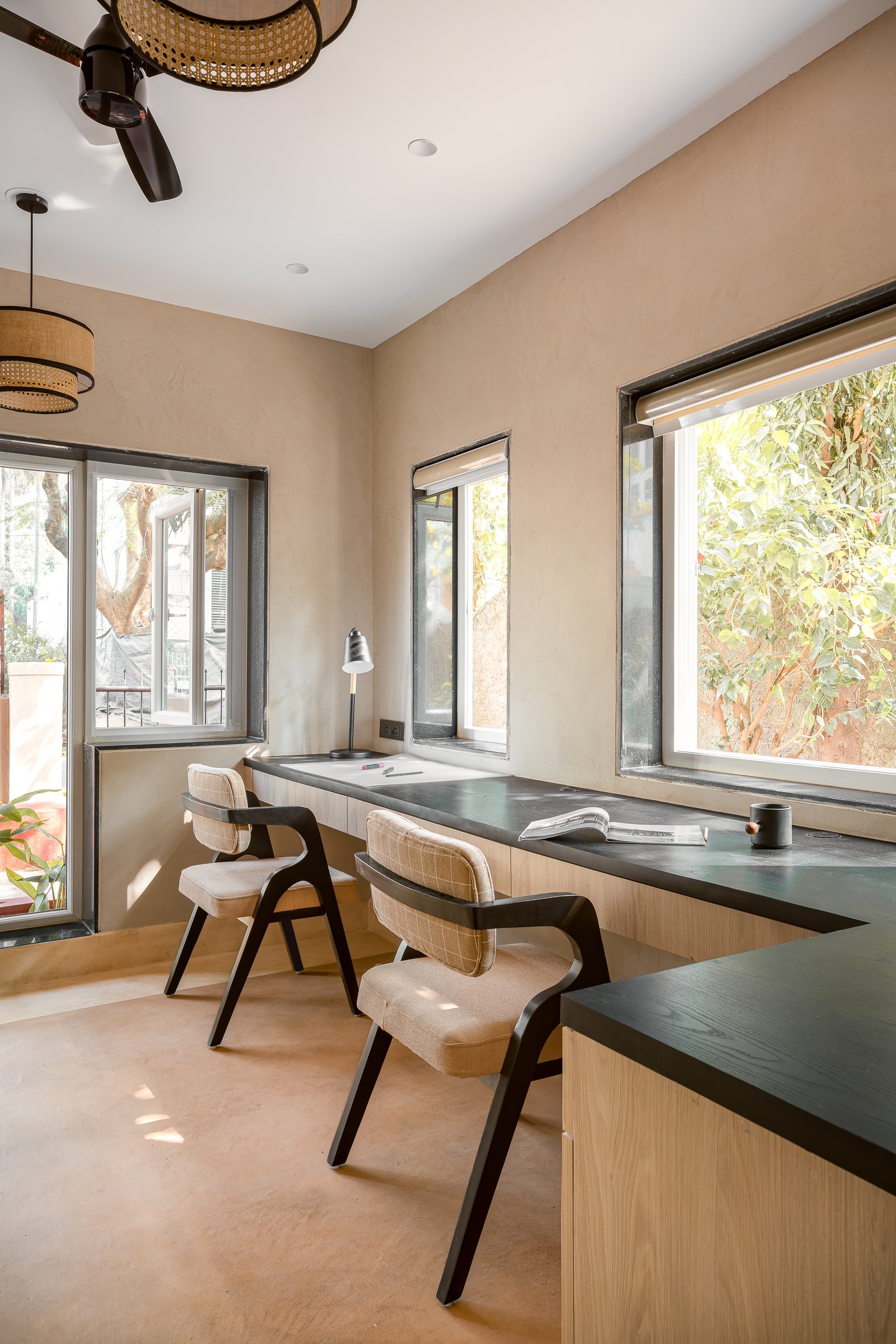 The main workstation: a long stone-topped counter set against three windows of foliage