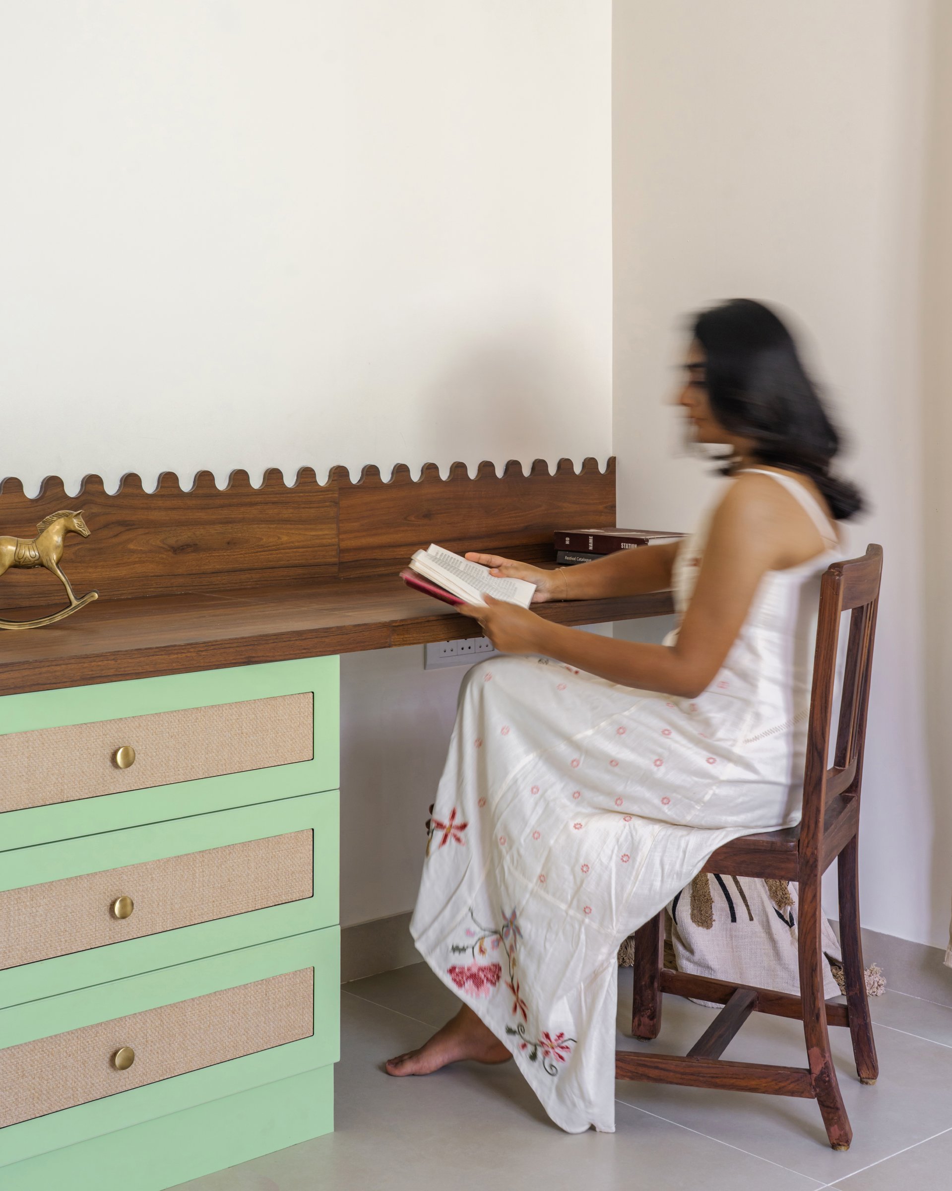 The study desk in use, with jute-panelled drawers and a slat-backed wooden chair