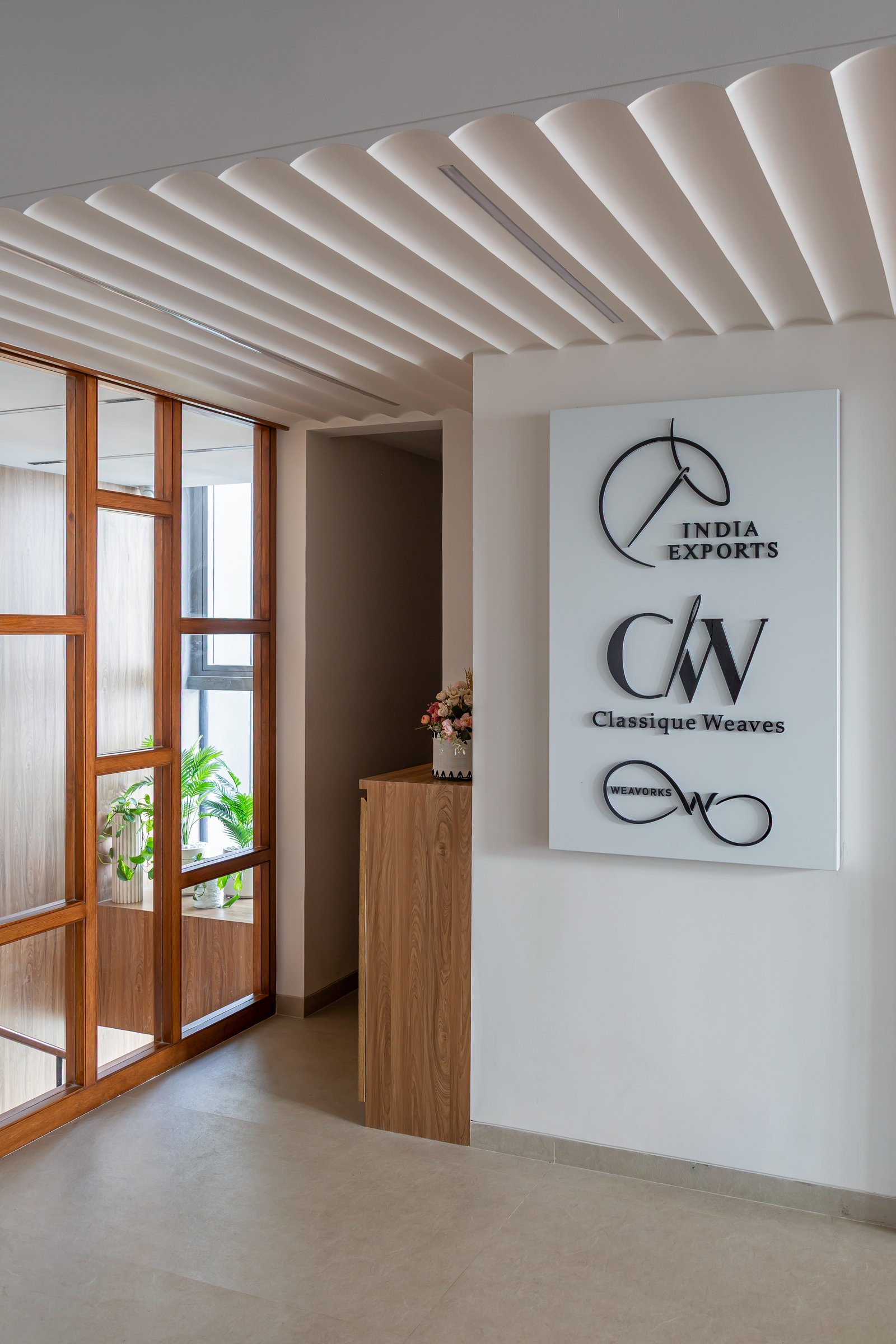 The signage wall at the entry, where the company's three sub-brand marks establish the project's identity before the working floors begin