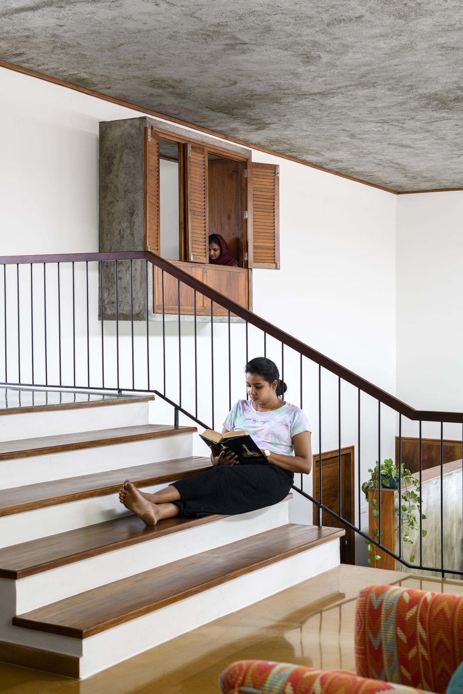 The staircase as a place of pause, with a small shuttered window opening onto the stair void