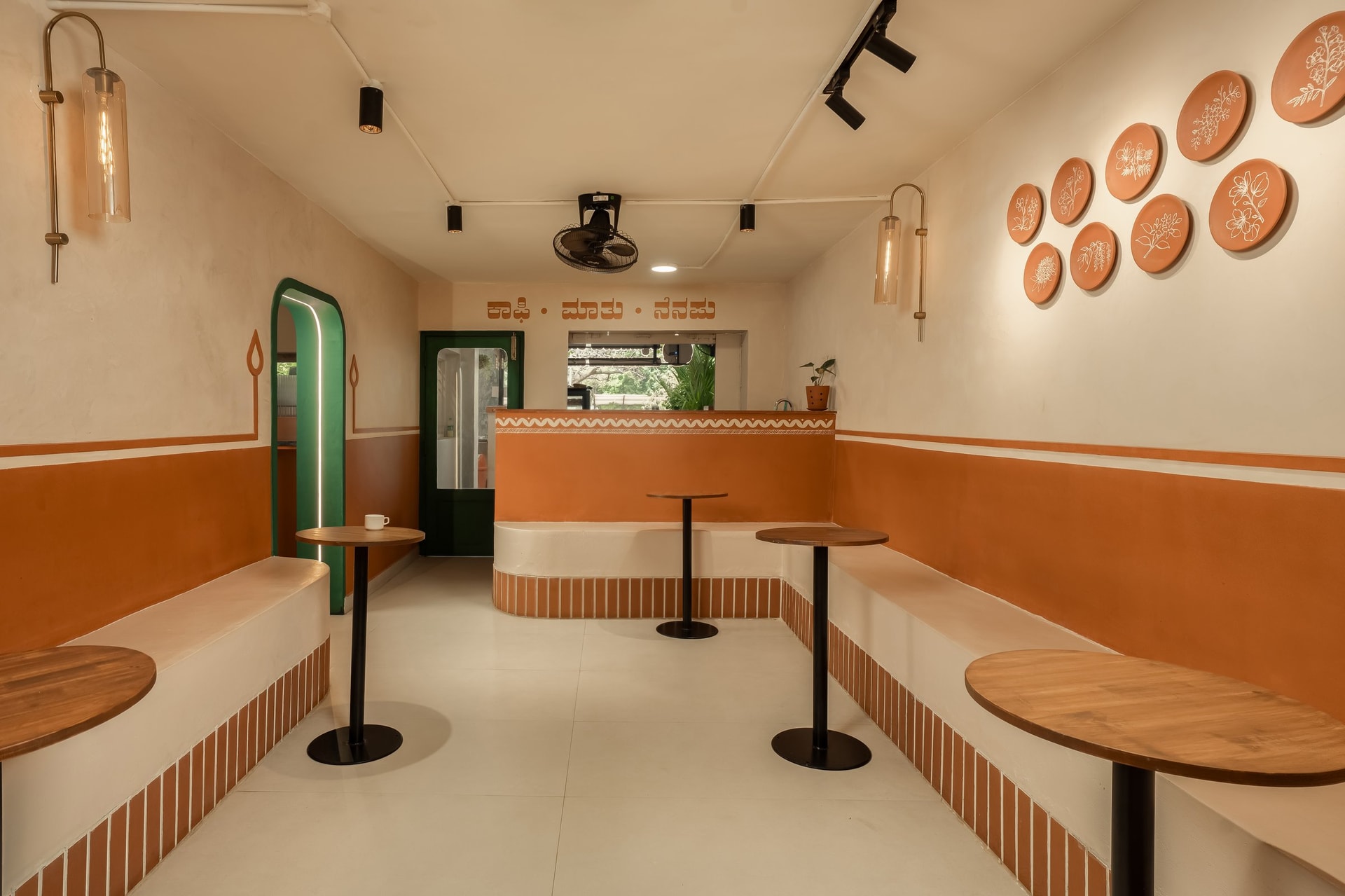 The Pilot Chef's dining hall, with built-in plaster benches, a central counter, and a wall of painted terracotta plates