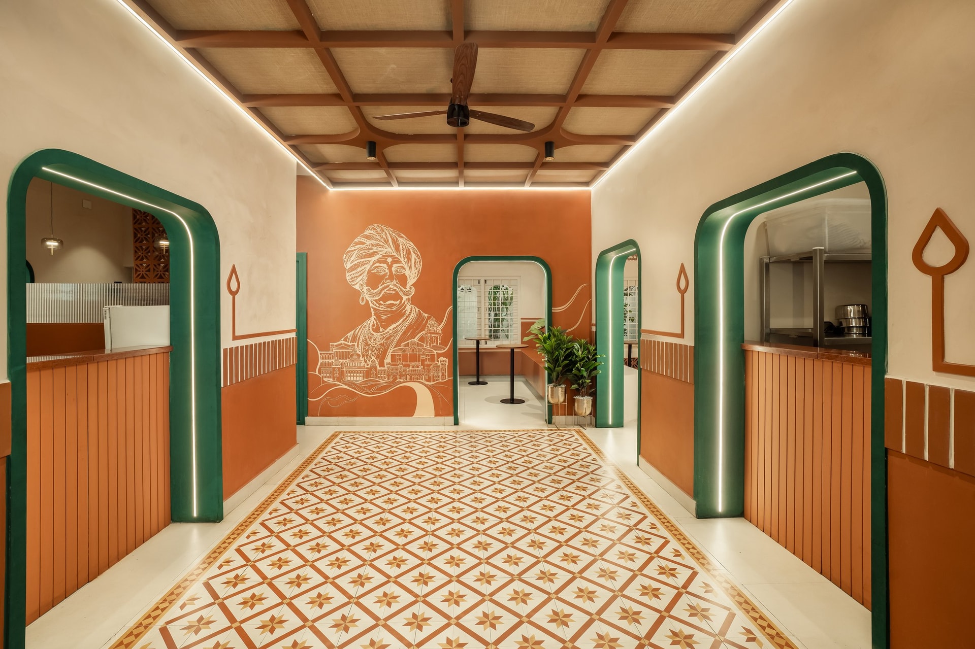 The main hall, with the Kempegowda mural at full scale and the ceiling fan set into a coffered wood-and-jute soffit