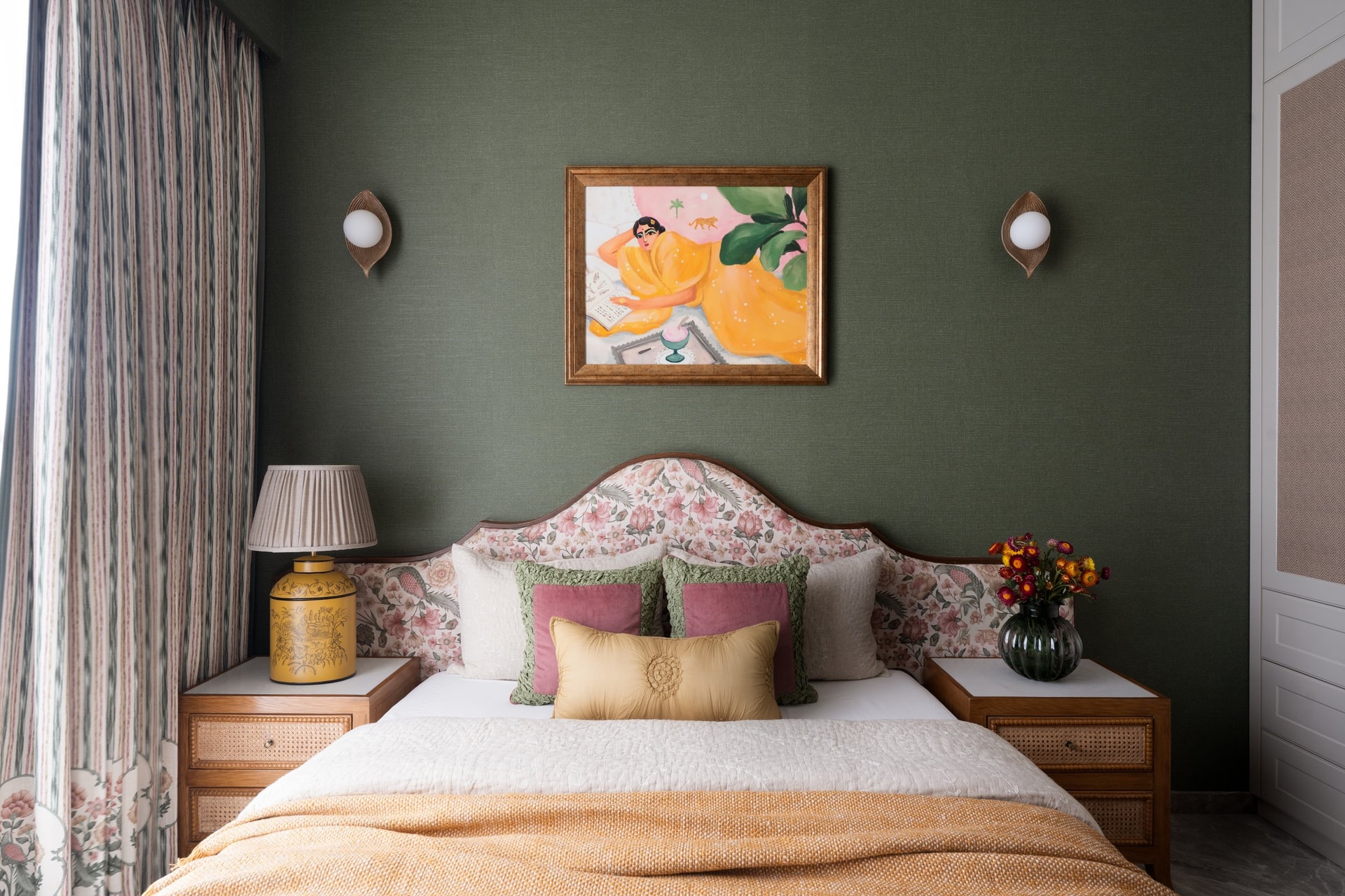 The parents' bedroom: olive-green grasscloth walls and a pink floral headboard, a softer register of the home's maximalism