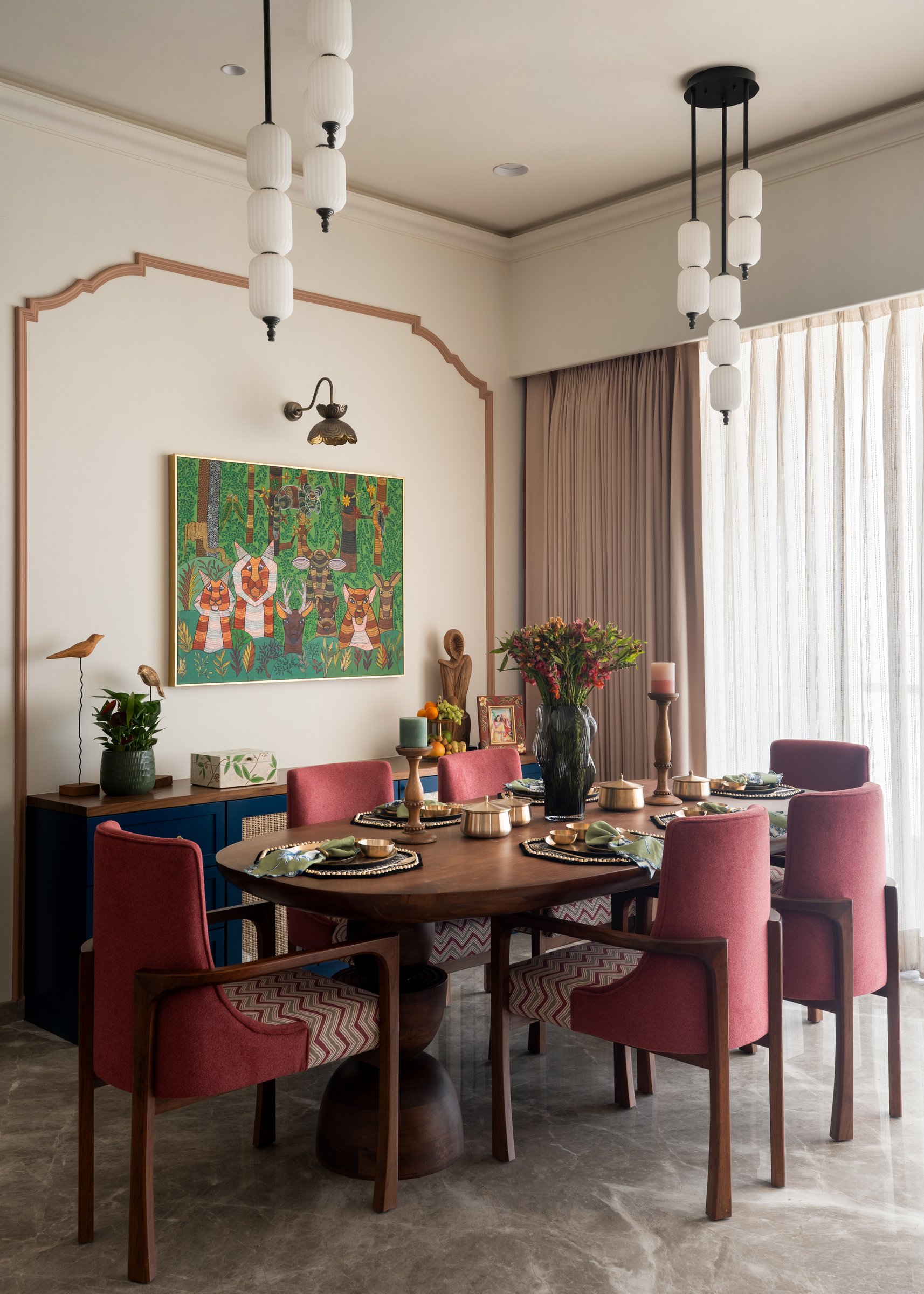 The dining room, anchored by a Gondwana Project artwork framed within a scalloped wall moulding