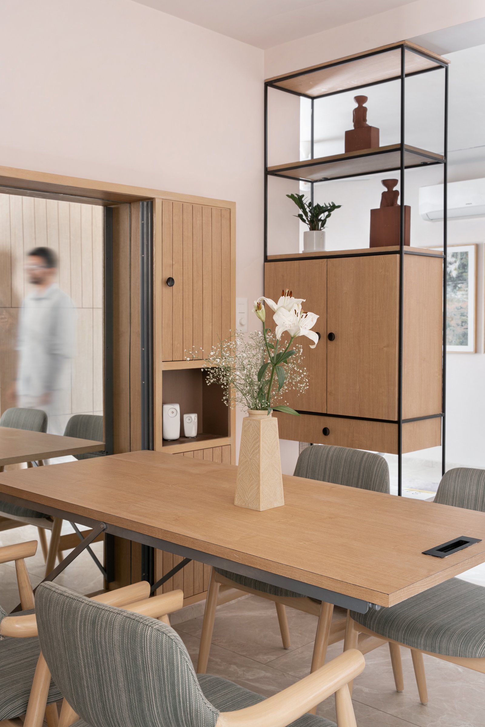 A closer view of the dining table, where the oak top meets a slender black metal frame