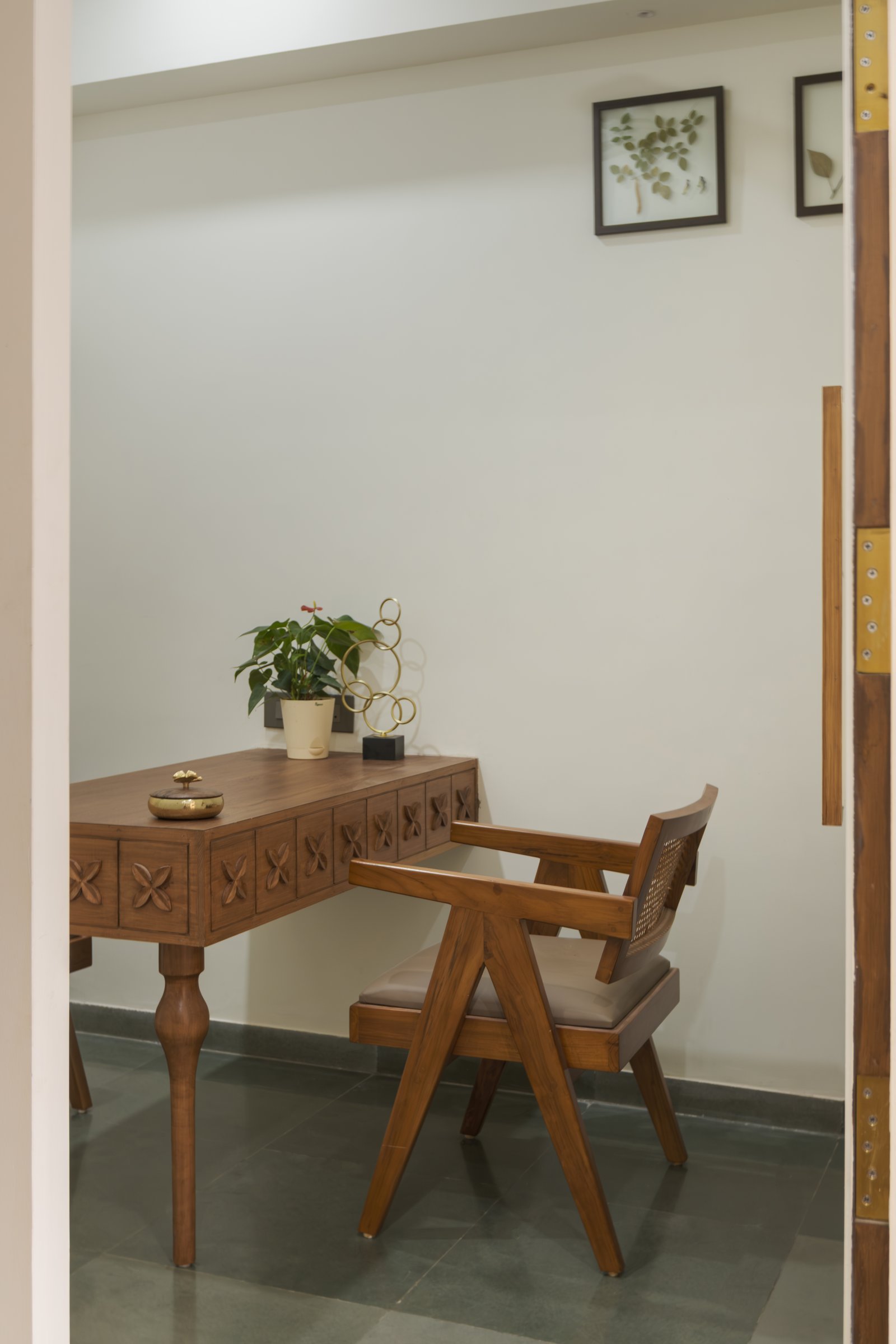 A quieter view of the same chamber, the pale walls left almost bare to let the carved furniture register as craft