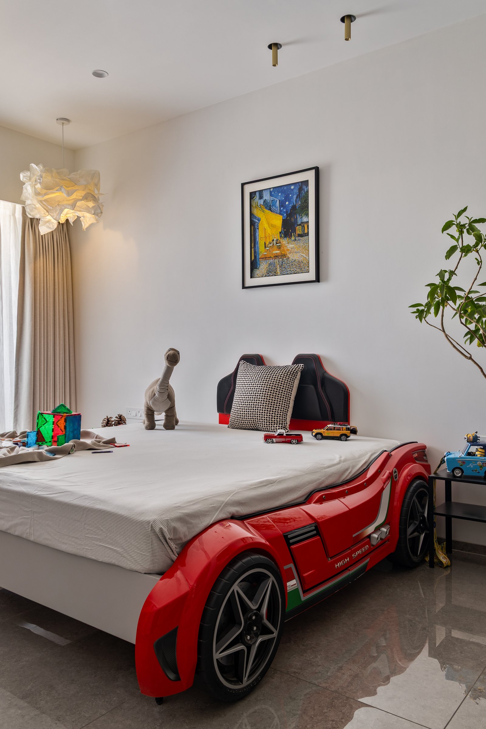 The sculpted car-form bed, the room's single extravagant gesture against an otherwise quiet wall