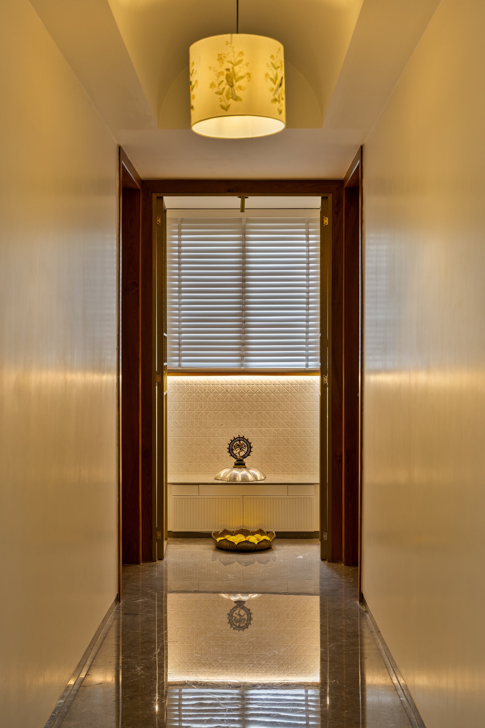 The puja room at the end of a softly lit passage, a small space of pause and reflection