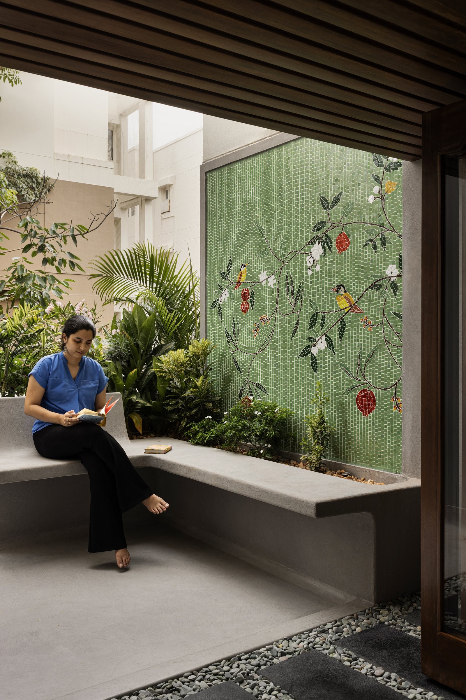 The mosaic wall, executed as a bird-and-branch composition where the traditional craft language finally arrives in full