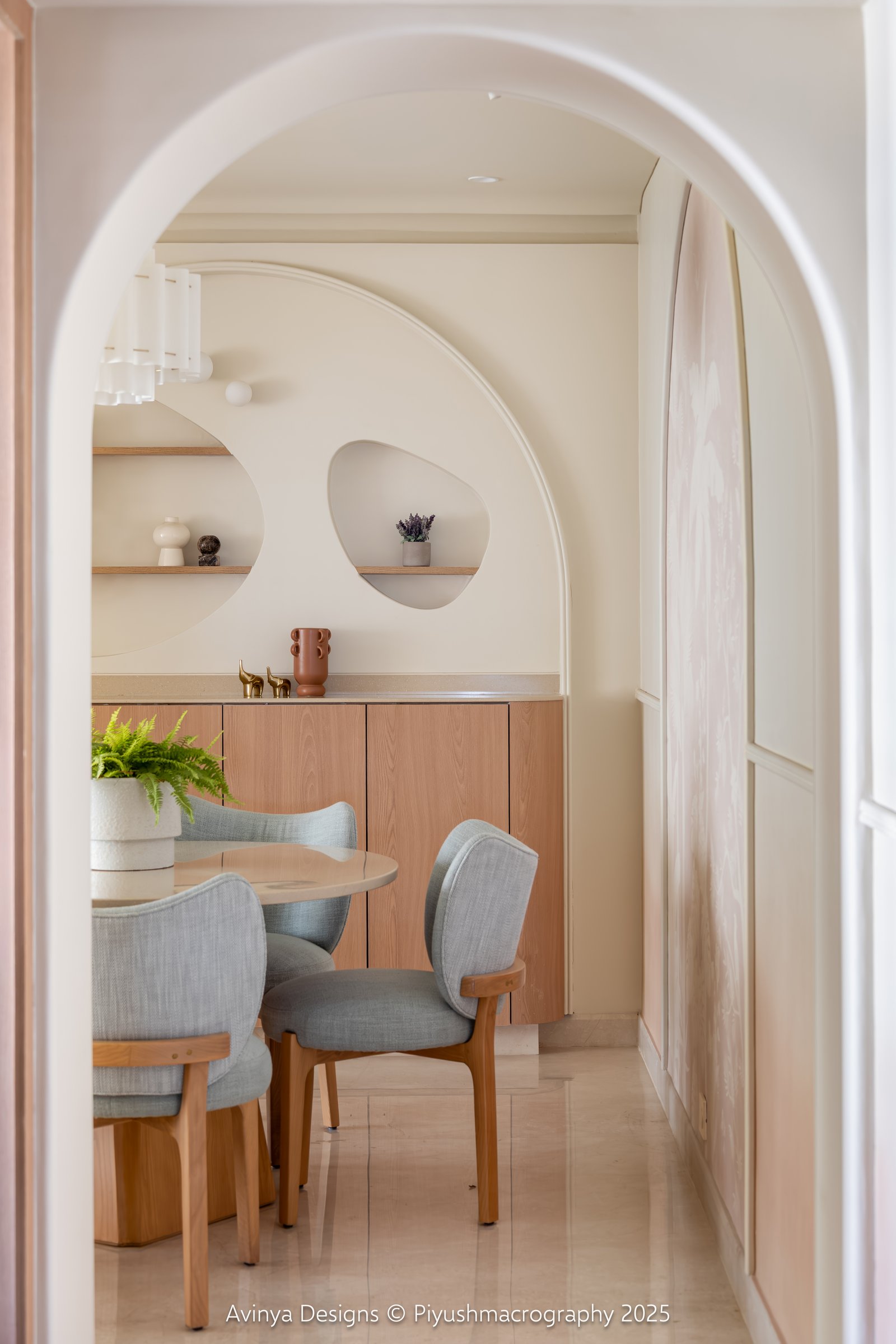 The dining nook seen through the passage arch, framed as an alcove within the home's spatial sequence