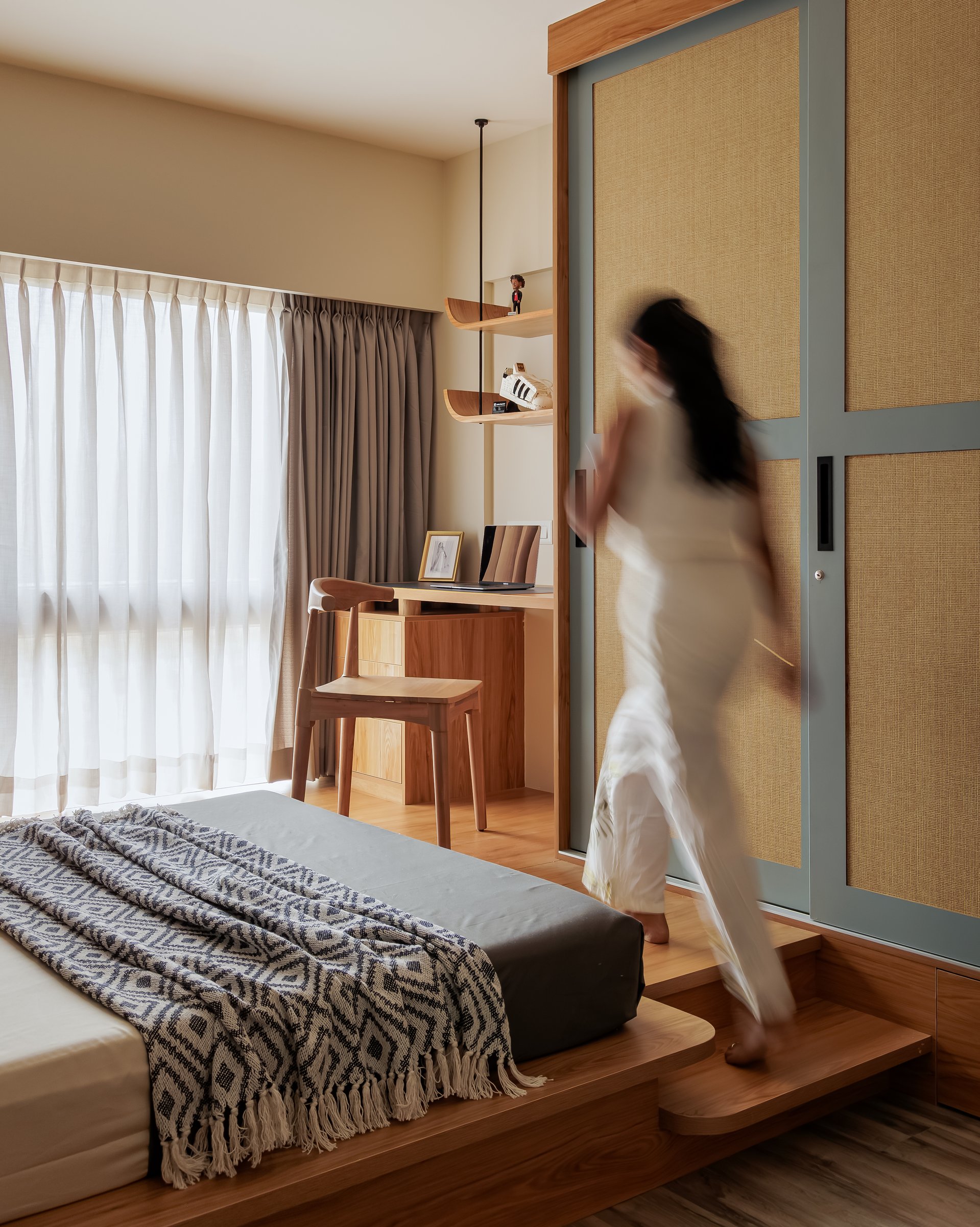A wider view of the child's bedroom, revealing the raised platform bed and a compact study nook folded into the corner