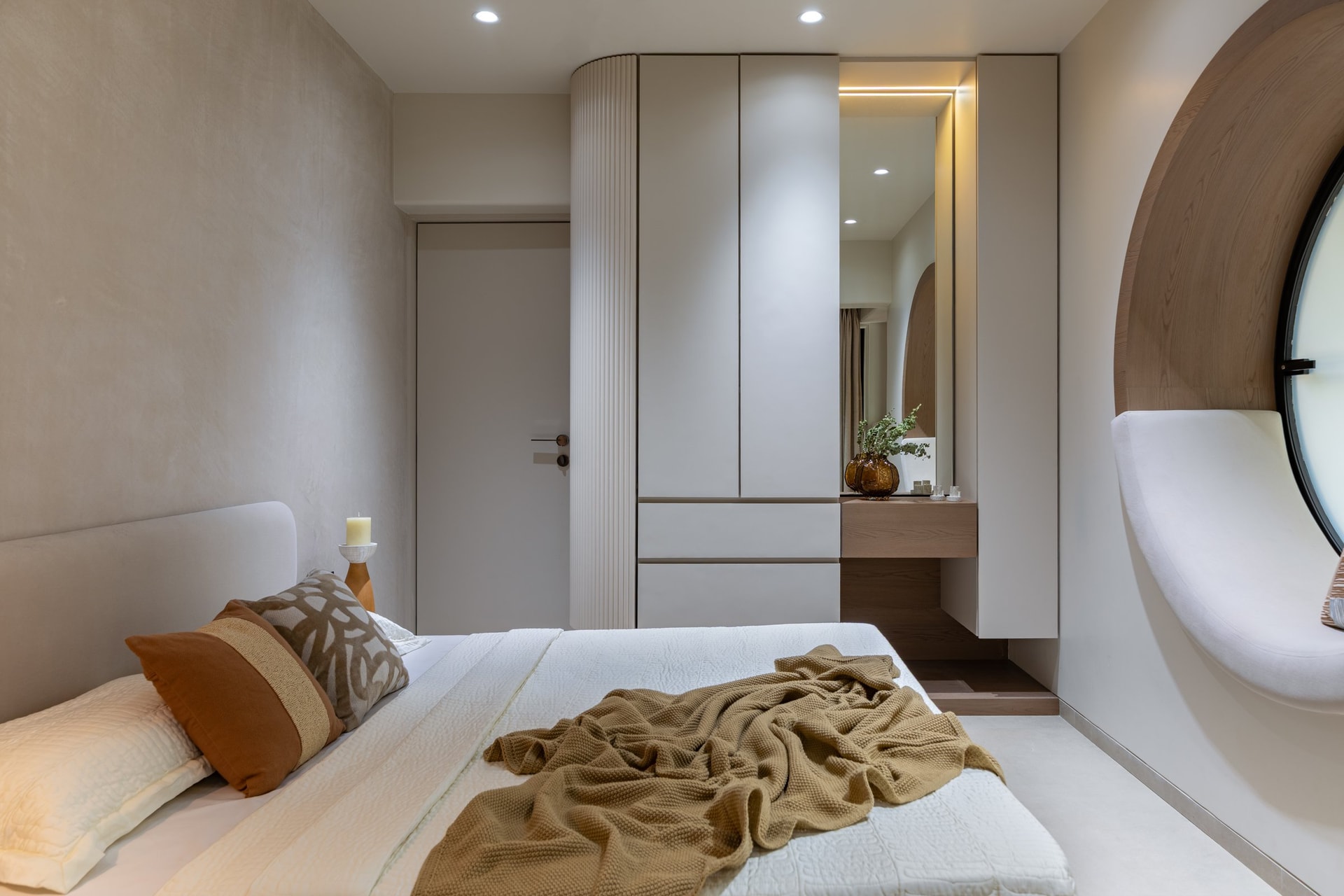 The second bedroom's compact dressing zone, where a full-height mirror doubles the perceived volume of the room