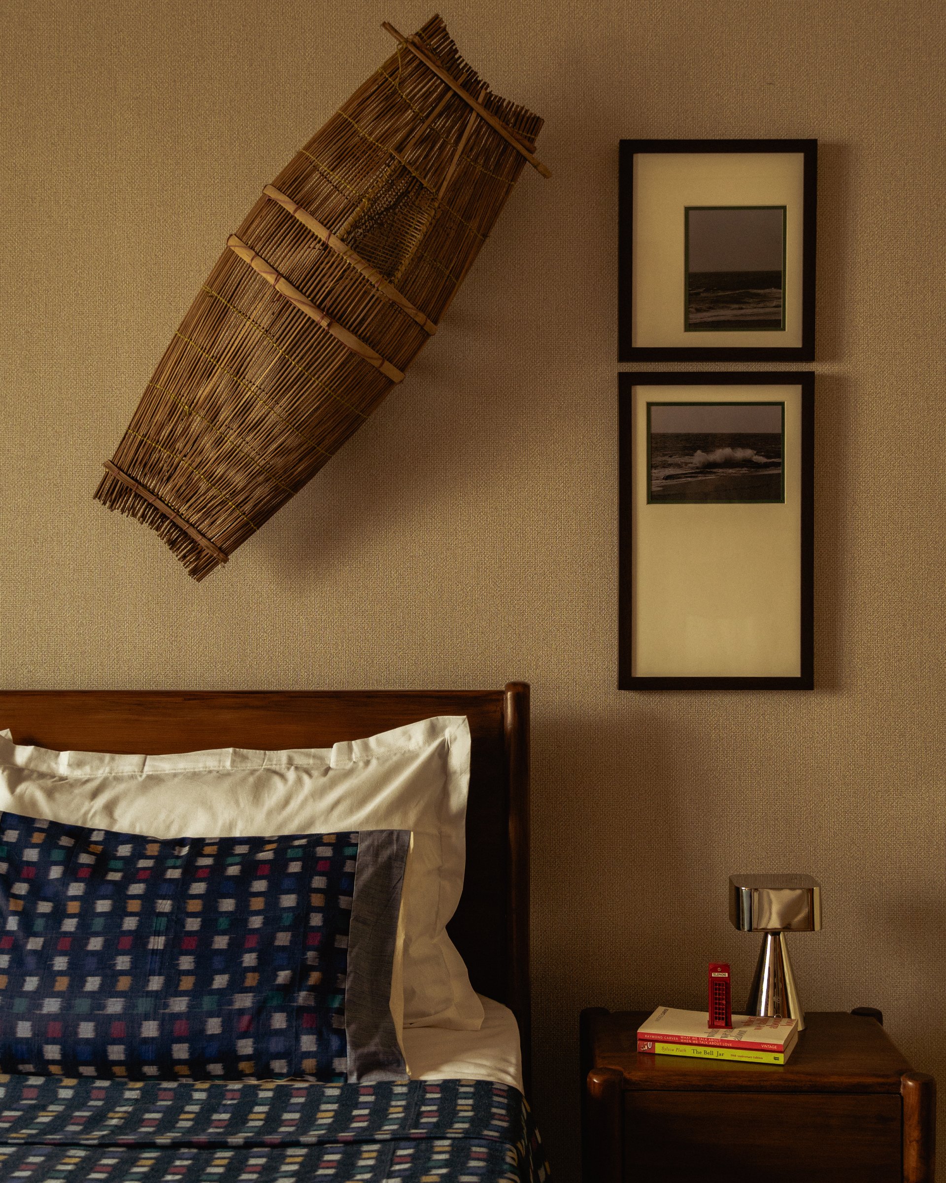 The parents' bedroom, where a woven bamboo Sepa fishing net is framed as artefact above the headboard