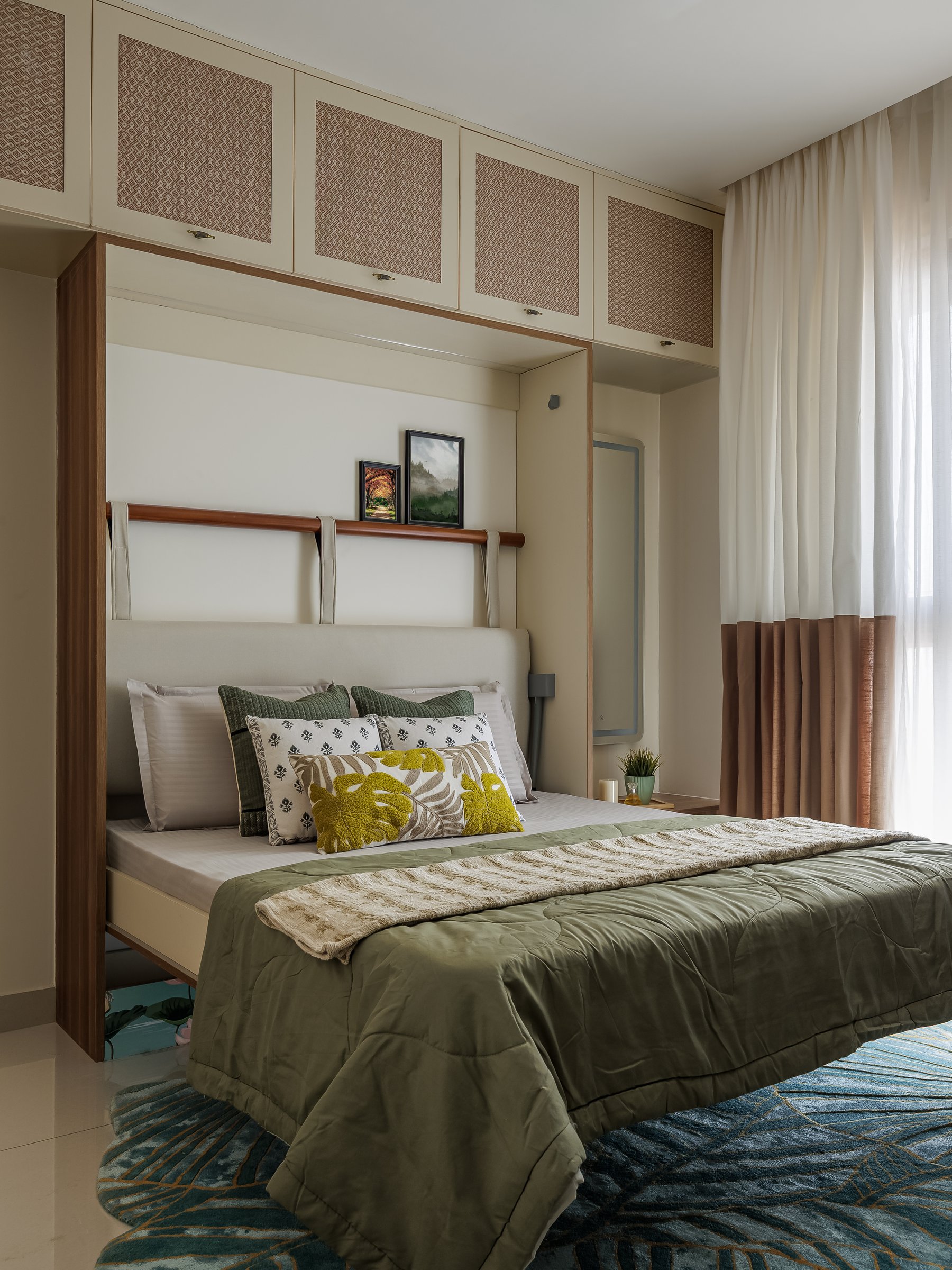 The bed opened, its upholstered headboard held by timber straps above teal and gold floor cushions