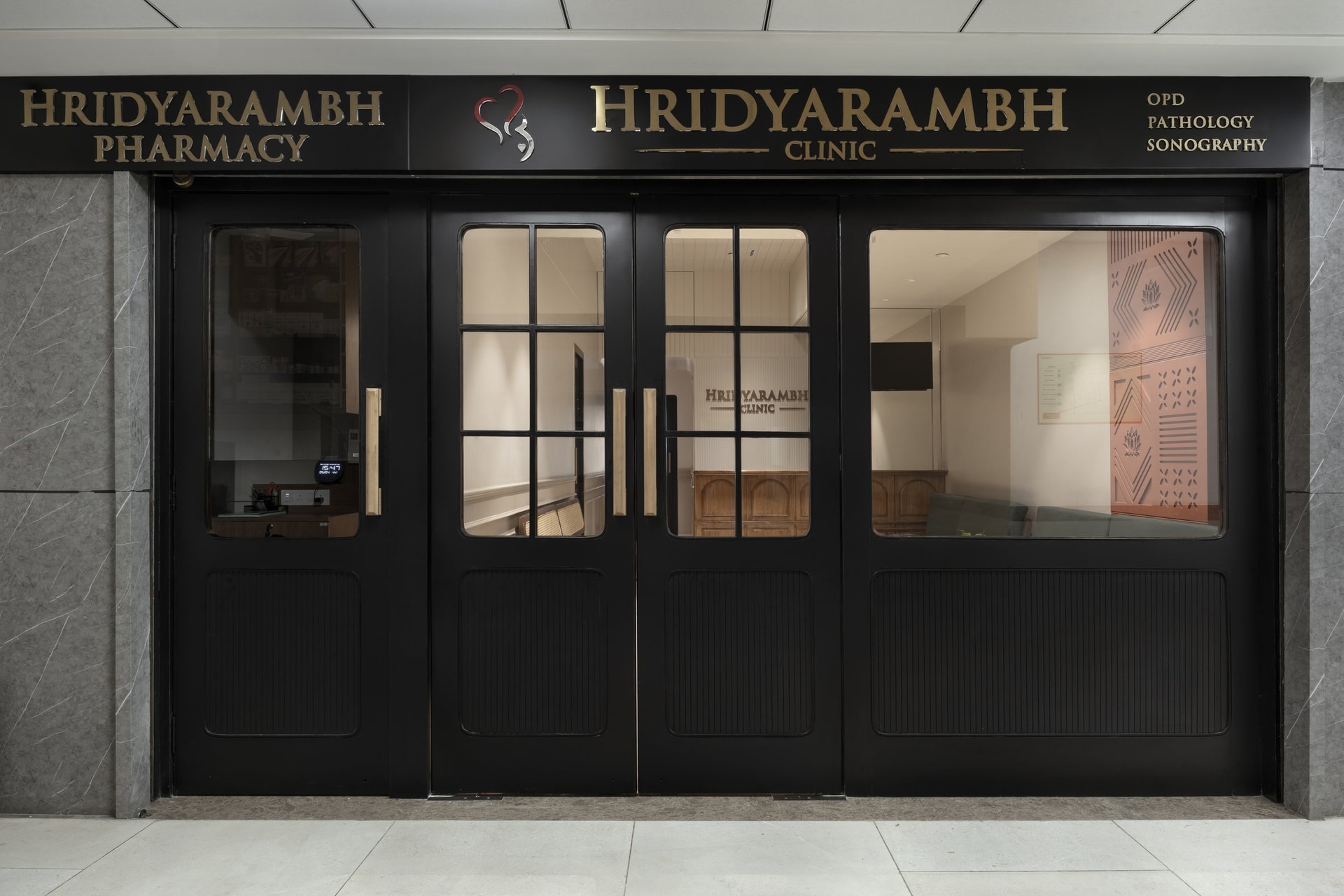 The facade, where matte black joinery and brushed gold typography reframe the clinic as a boutique storefront