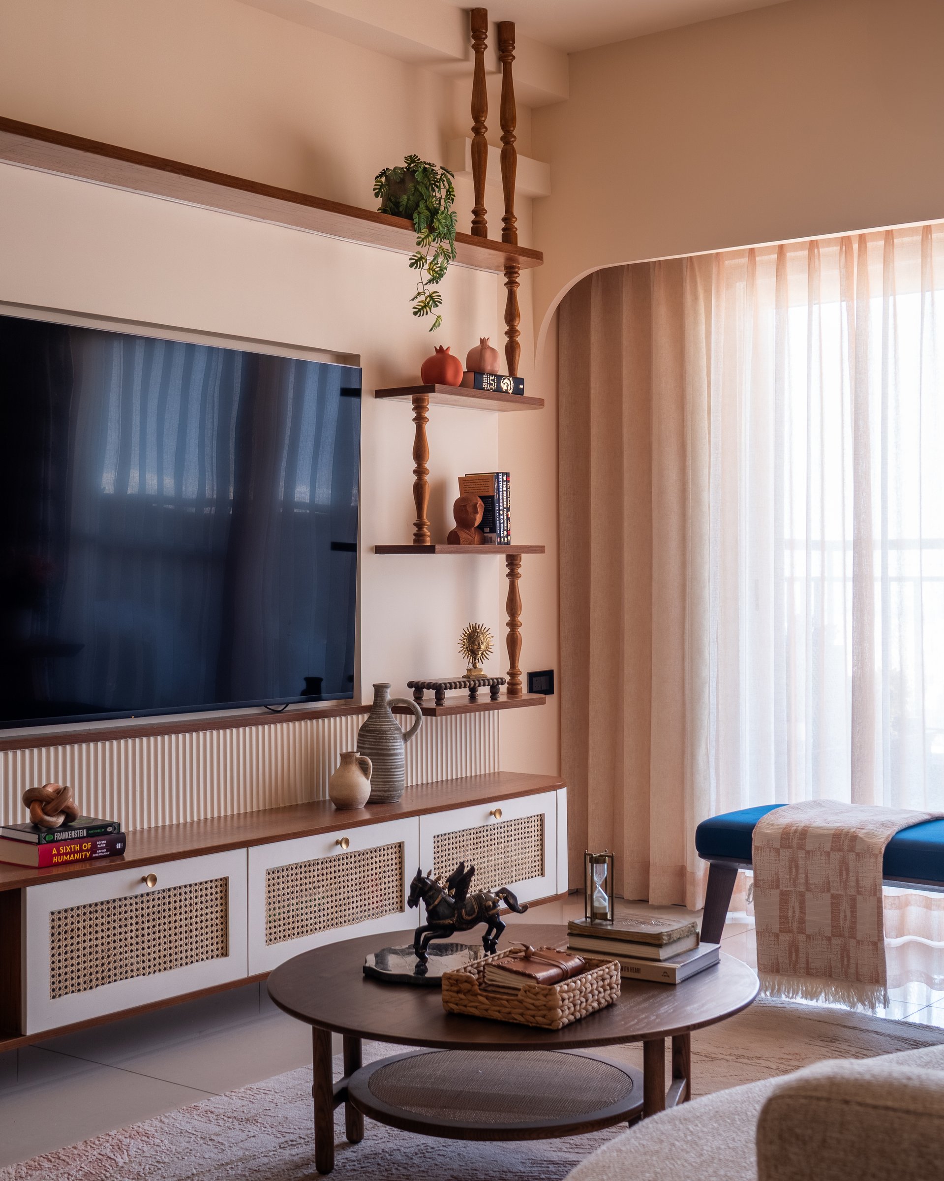 The living room's media wall, where reeded panelling, cane-fronted cabinets, and turned wooden spindles reinterpret kadasal detailing in a contemporary register