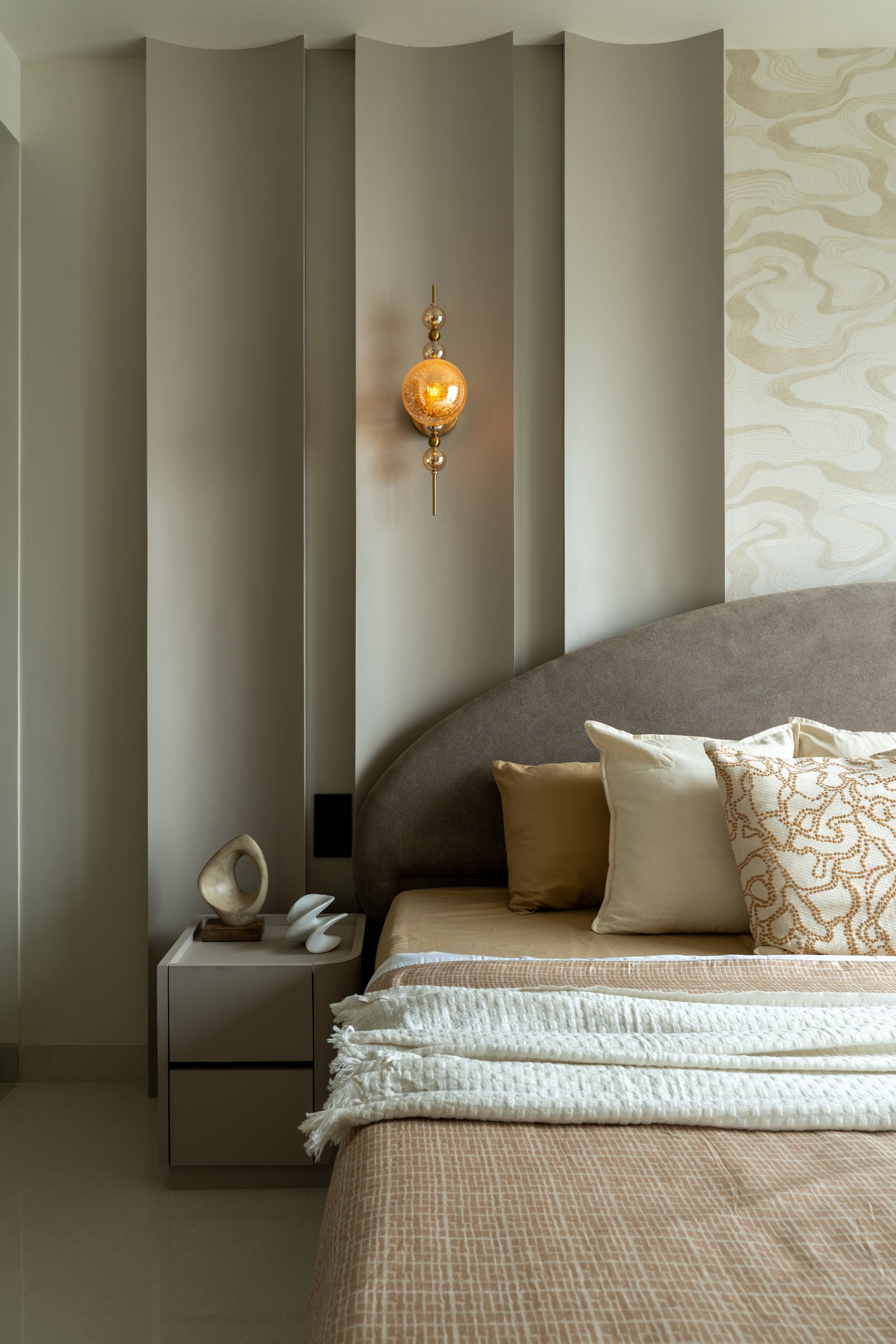 The fluted panelling seen closer, its soft undulations balancing the rounded headboard