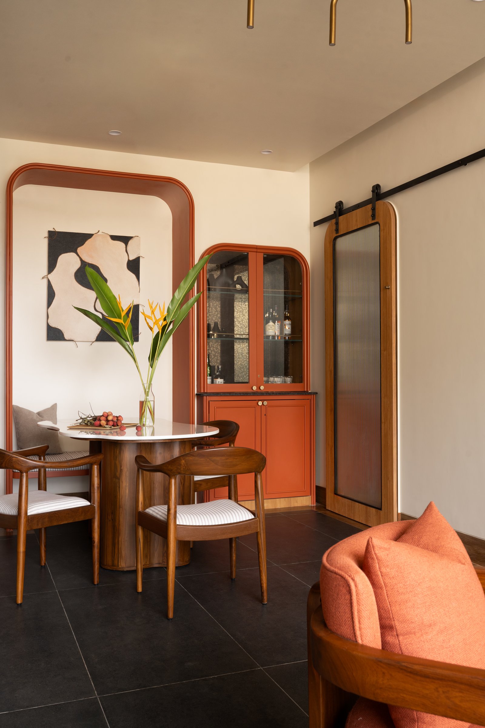 The bar cabinet and reeded-glass barn door, closing off the service zone with architectural presence