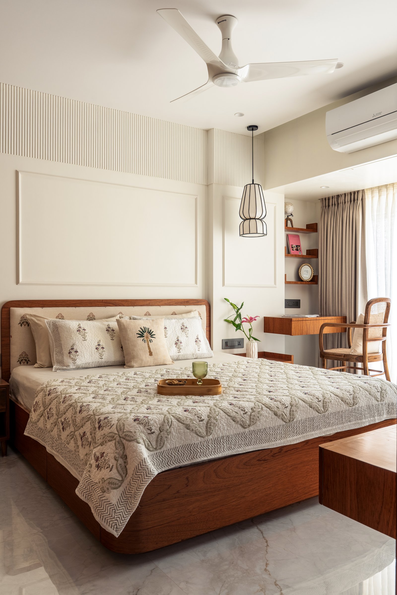 The guest bedroom, where a block-printed headboard and a compact teak writing desk fold study into the room