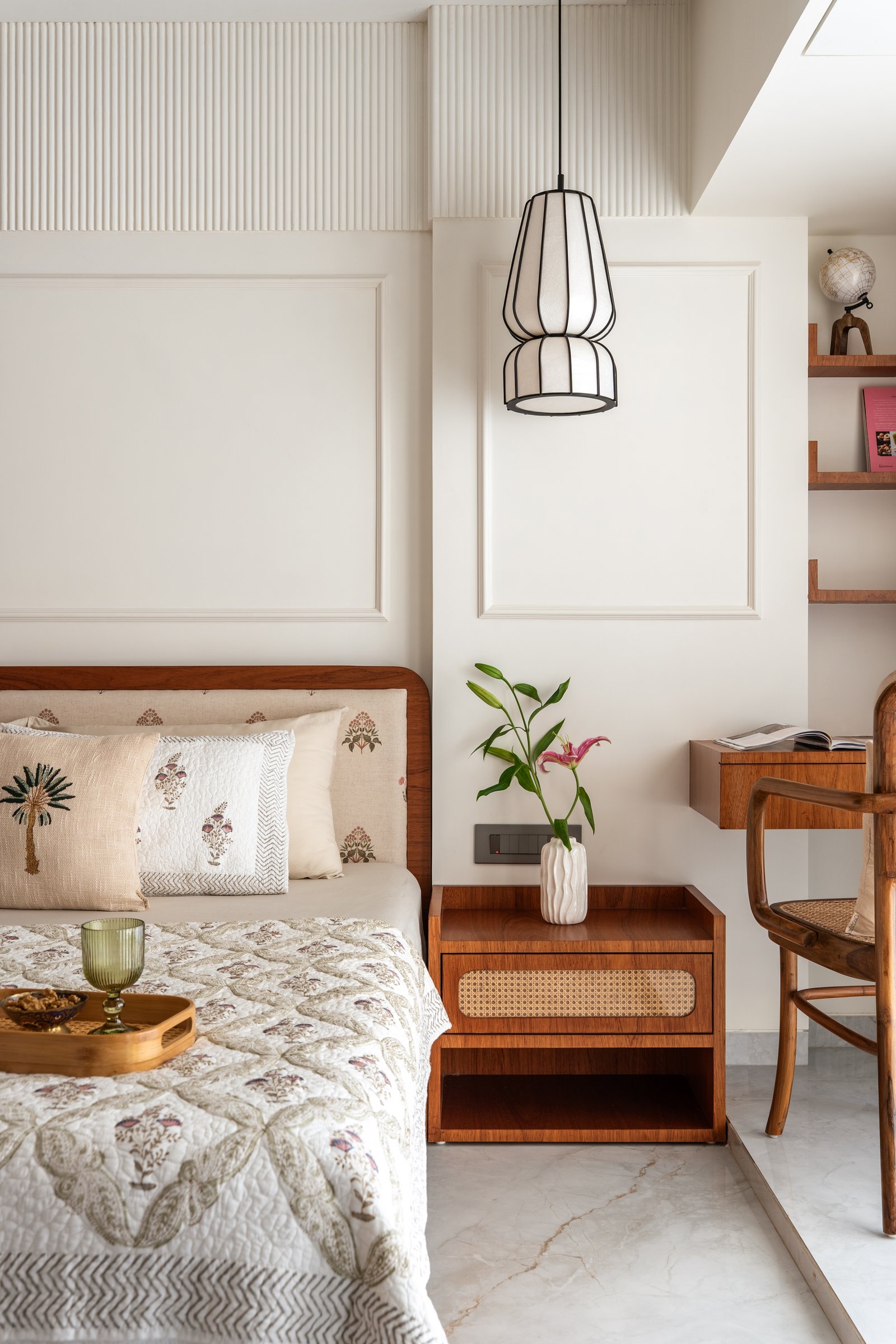 A closer view: teak bedside cabinet, cane-fronted drawer, and a run of open shelves above the desk