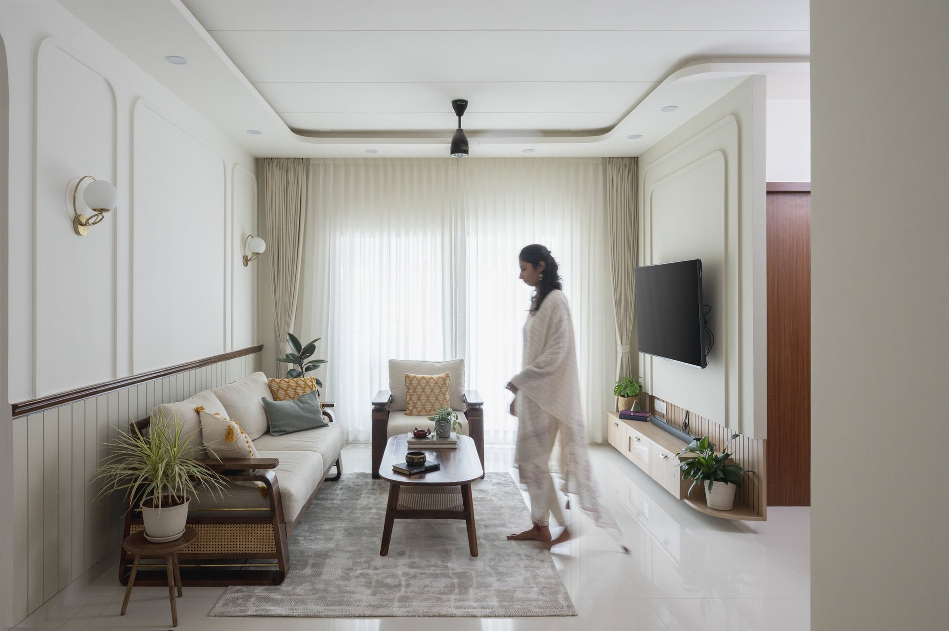 A conversational grouping composed of dark timber, warm neutrals, and a soft grey rug