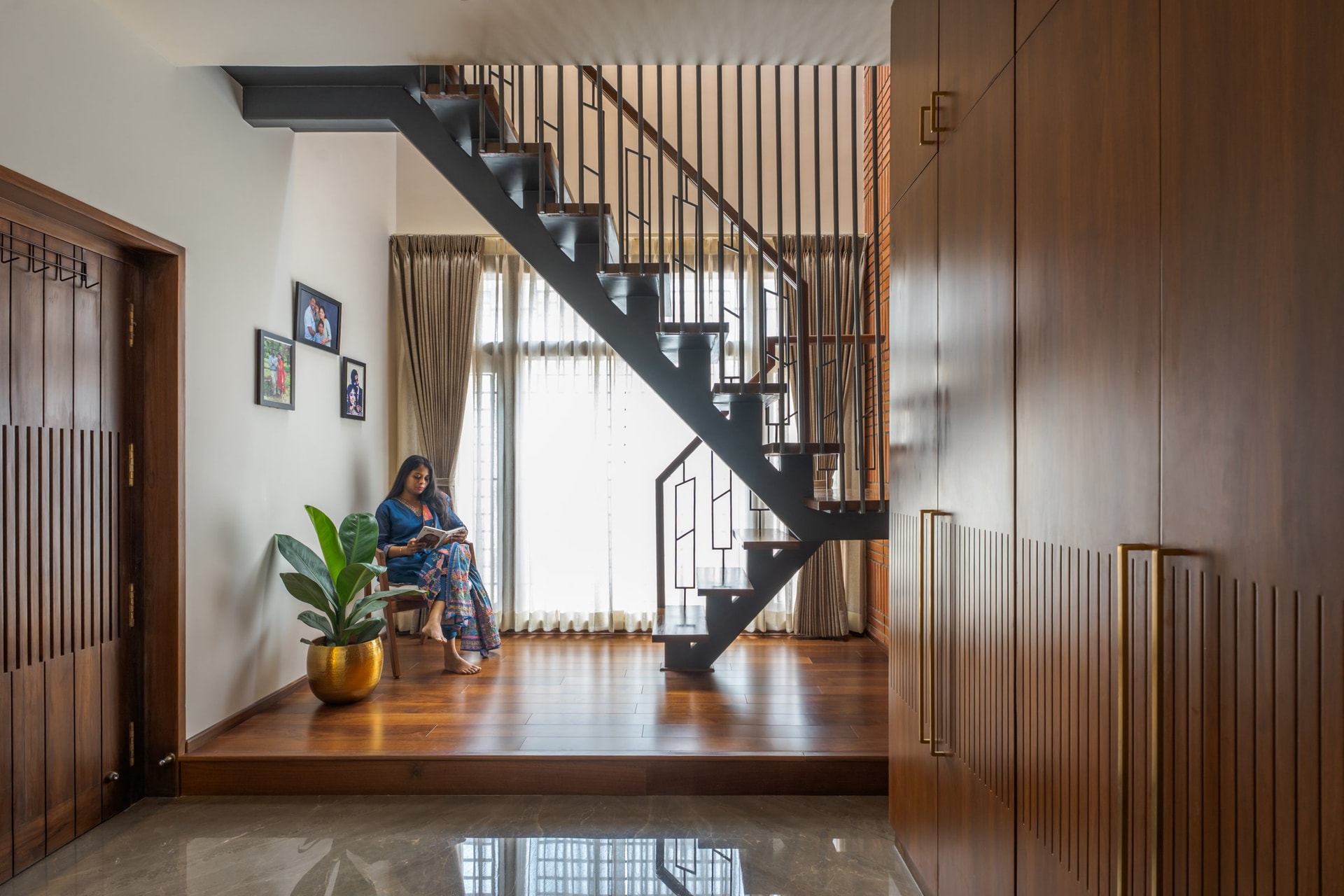 The interconnecting staircase, with a blackened steel stringer, timber treads, and a raised platform below that functions as a reading nook