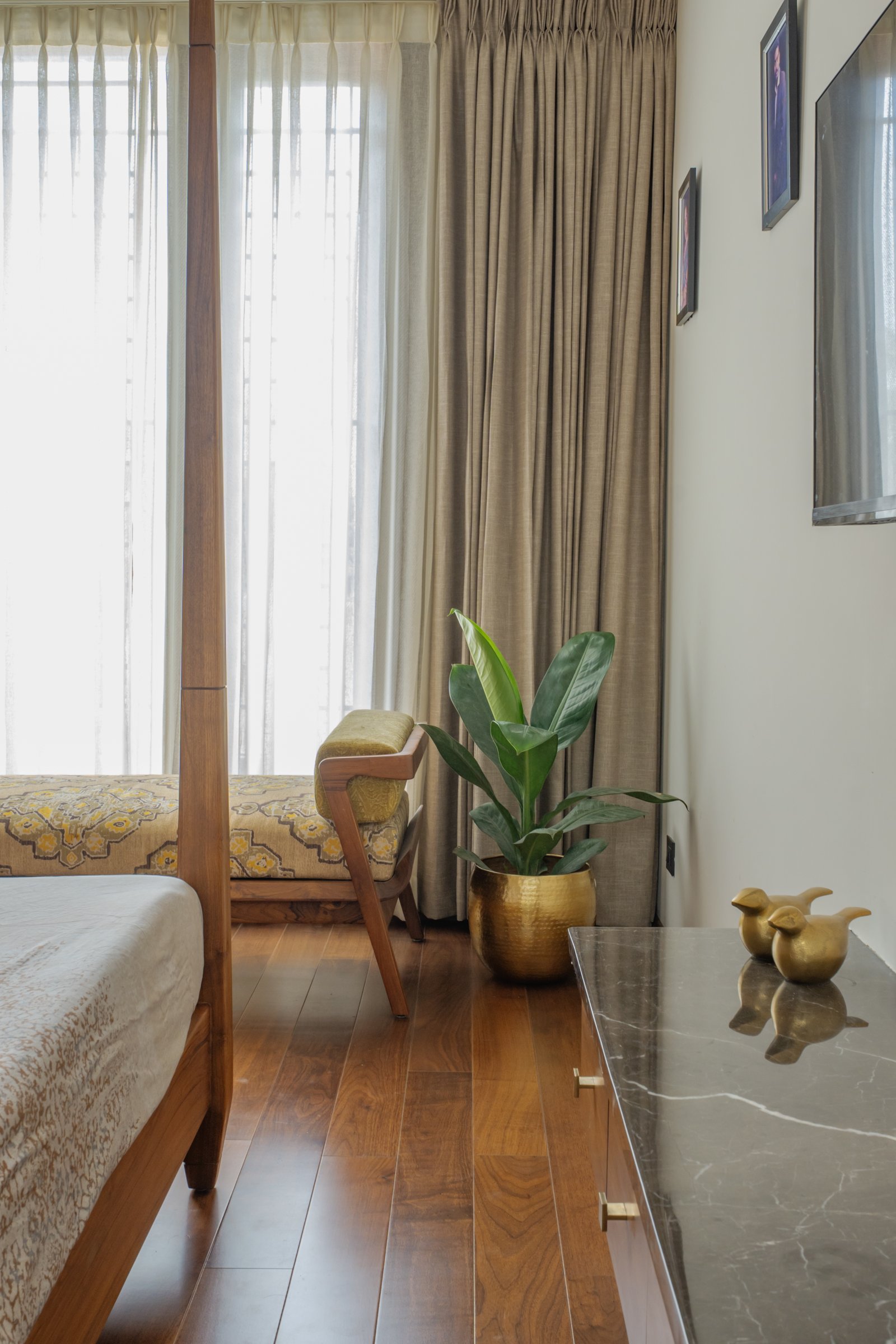 A closer view of the primary bedroom, where a stone-topped console and brass accents extend the home's warm-metal palette