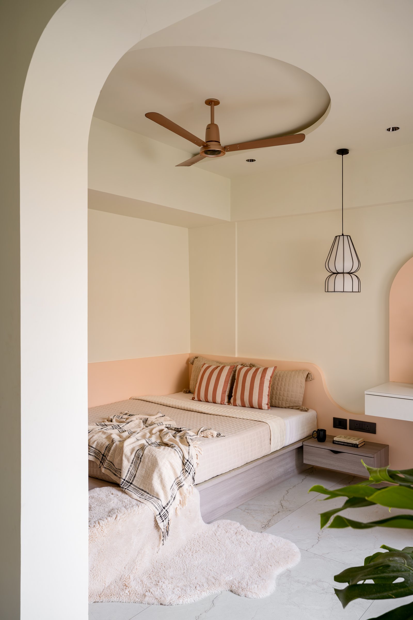 The daughter's bedroom, where a curved ceiling drop and a peach-toned wall soften the sleeping alcove