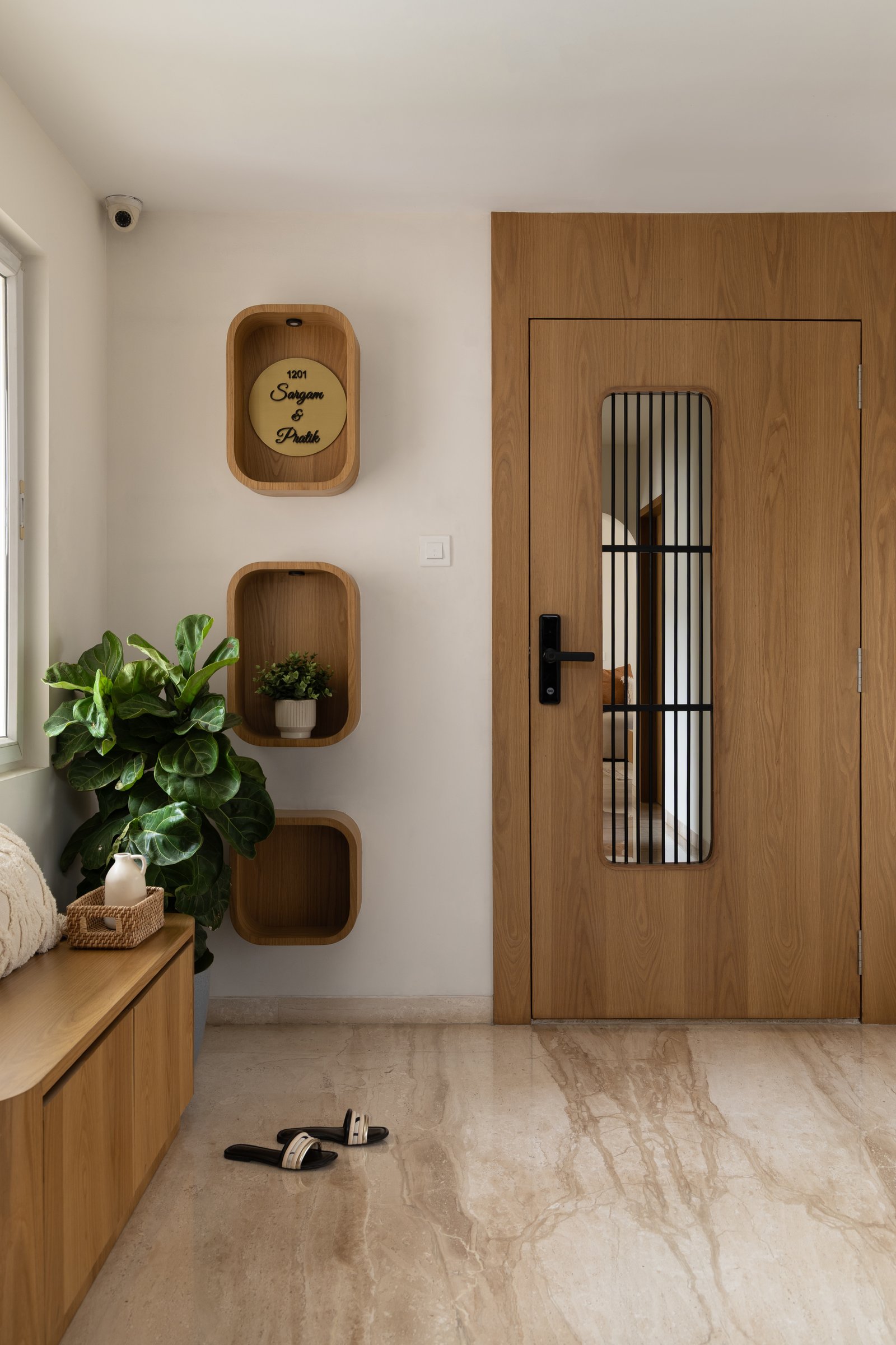 The entry: a warm timber door and three rounded niches establish the home's material register