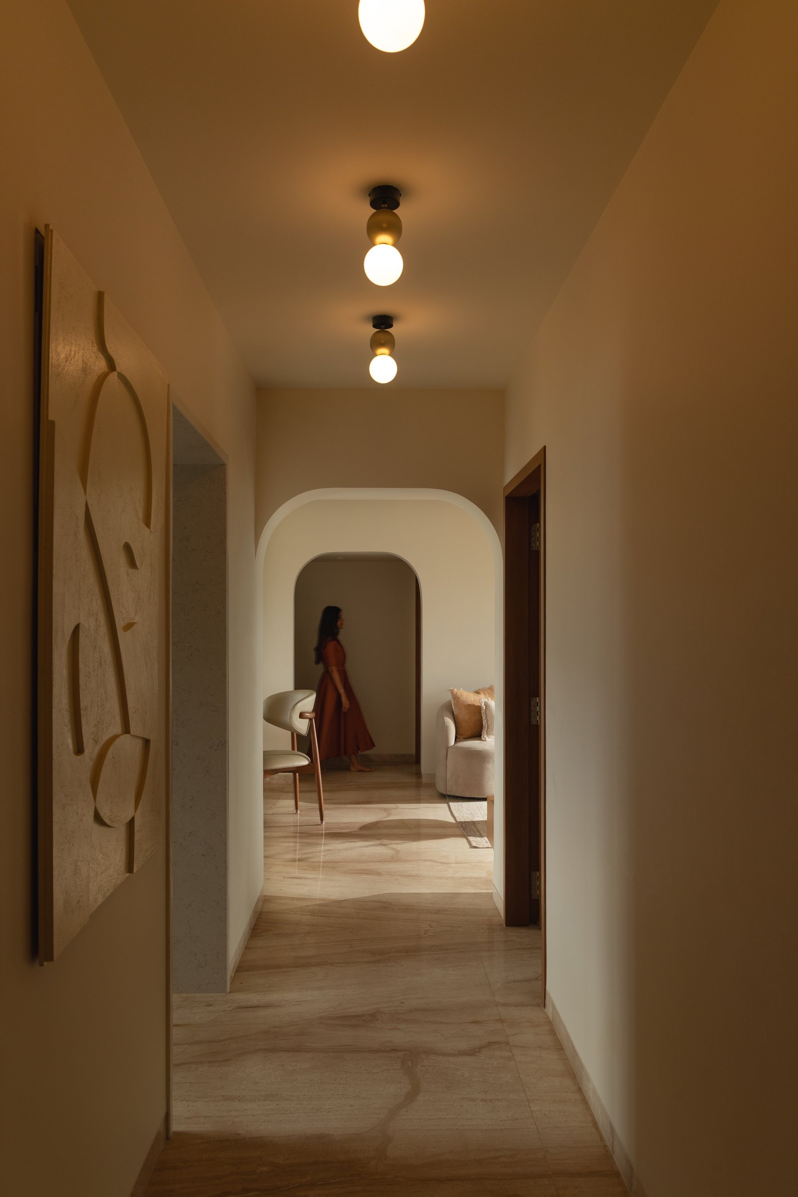 The passage between public and private zones, articulated by arched openings and globe fixtures