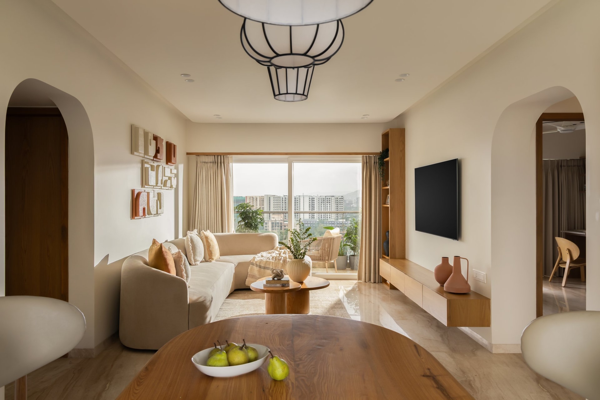 The living room, framed on either side by soft-edged arches that open into adjacent volumes