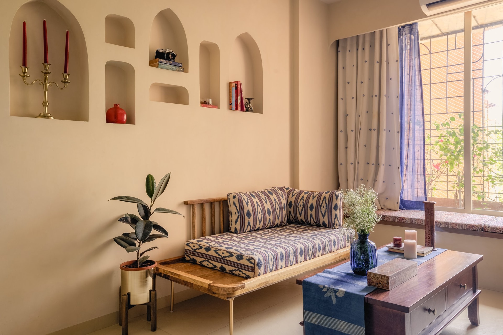 Ikat upholstery and a carved wooden coffee table anchor the compact living room