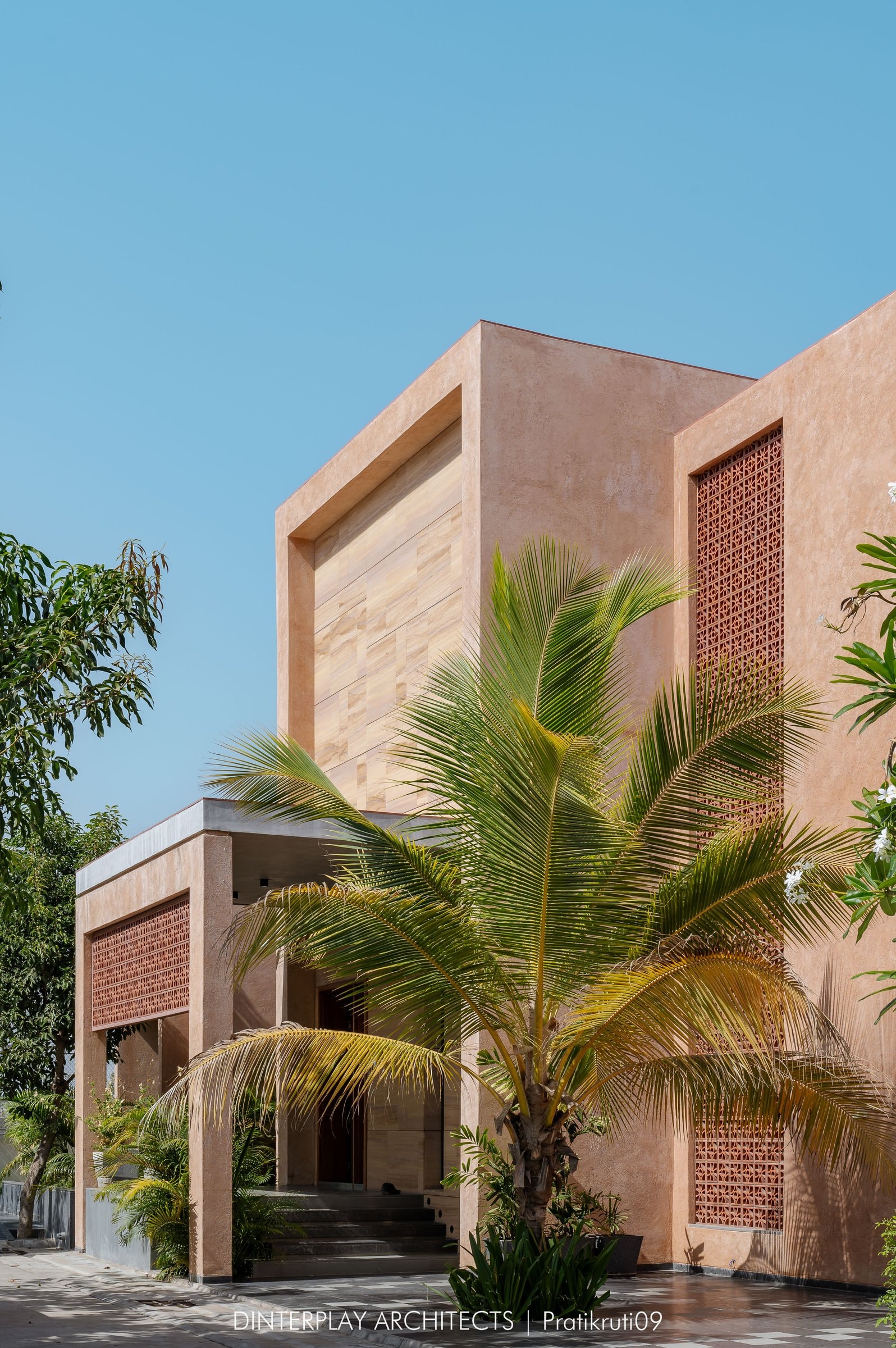 The plaster and sandstone facade, with jaali screens set flush into the upper mass