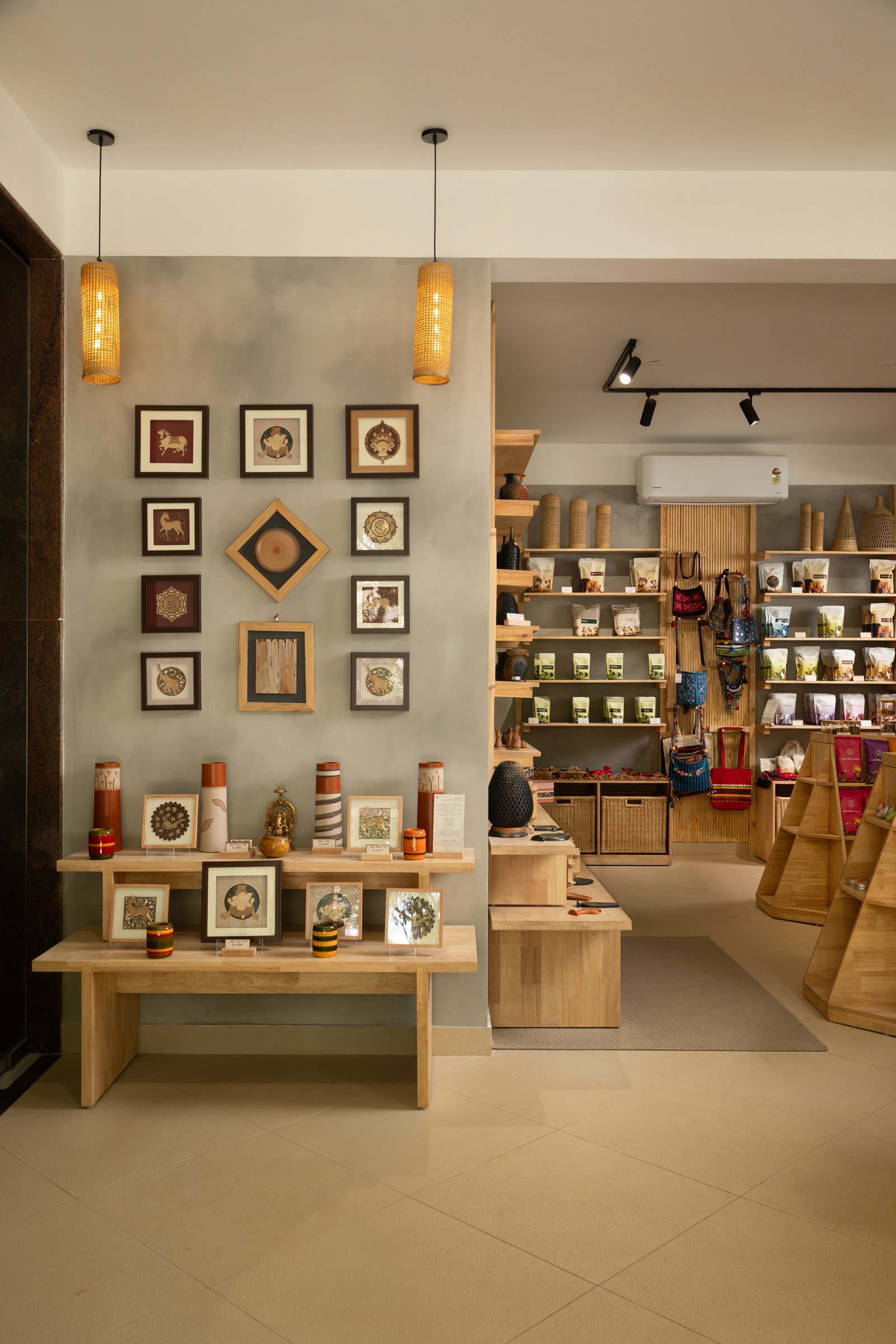The threshold between café and retail: framed folk-art miniatures and a low display console mark the transition without dividing the room