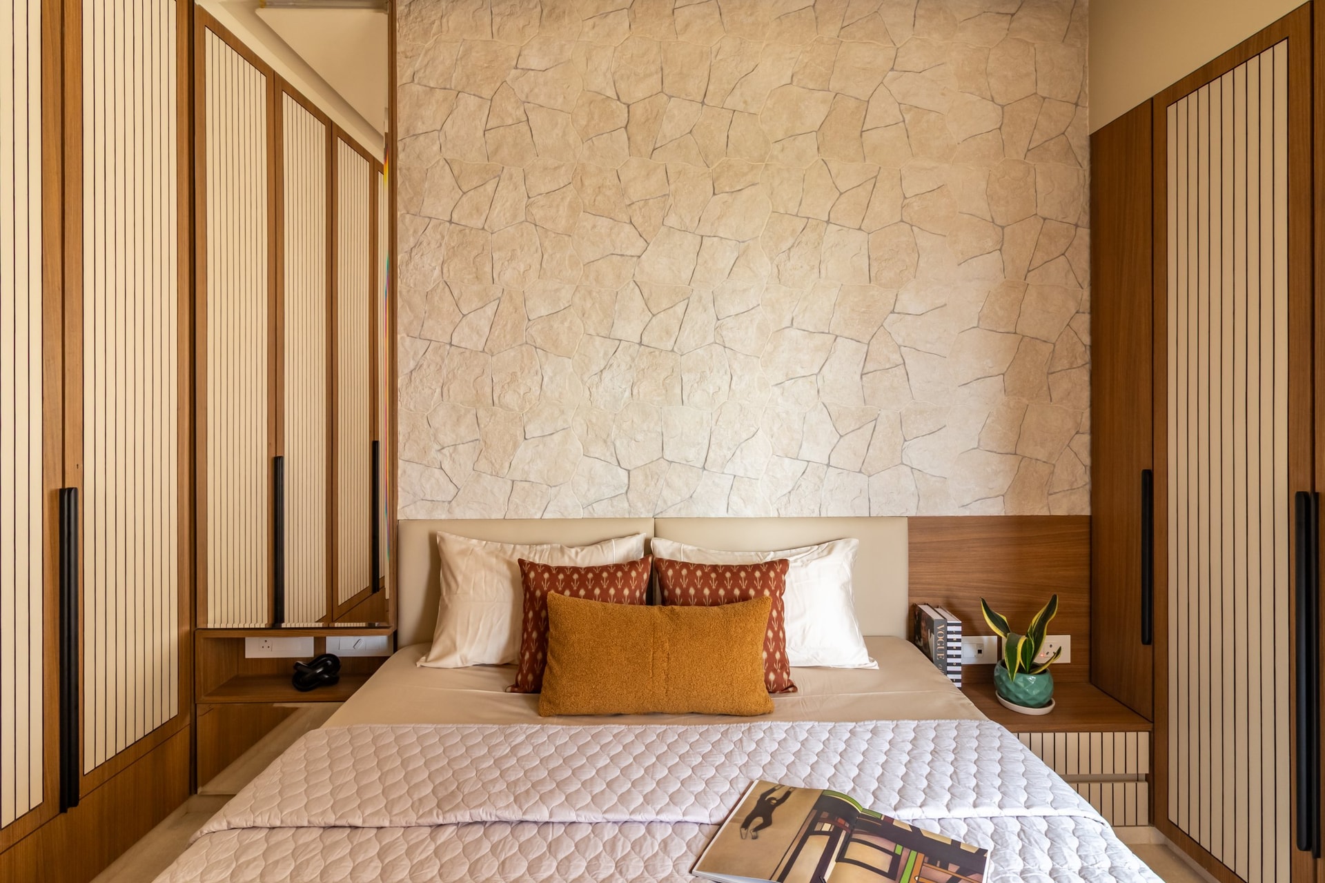 A second bedroom, where a crazy-paved stone wall introduces a more sculptural material register