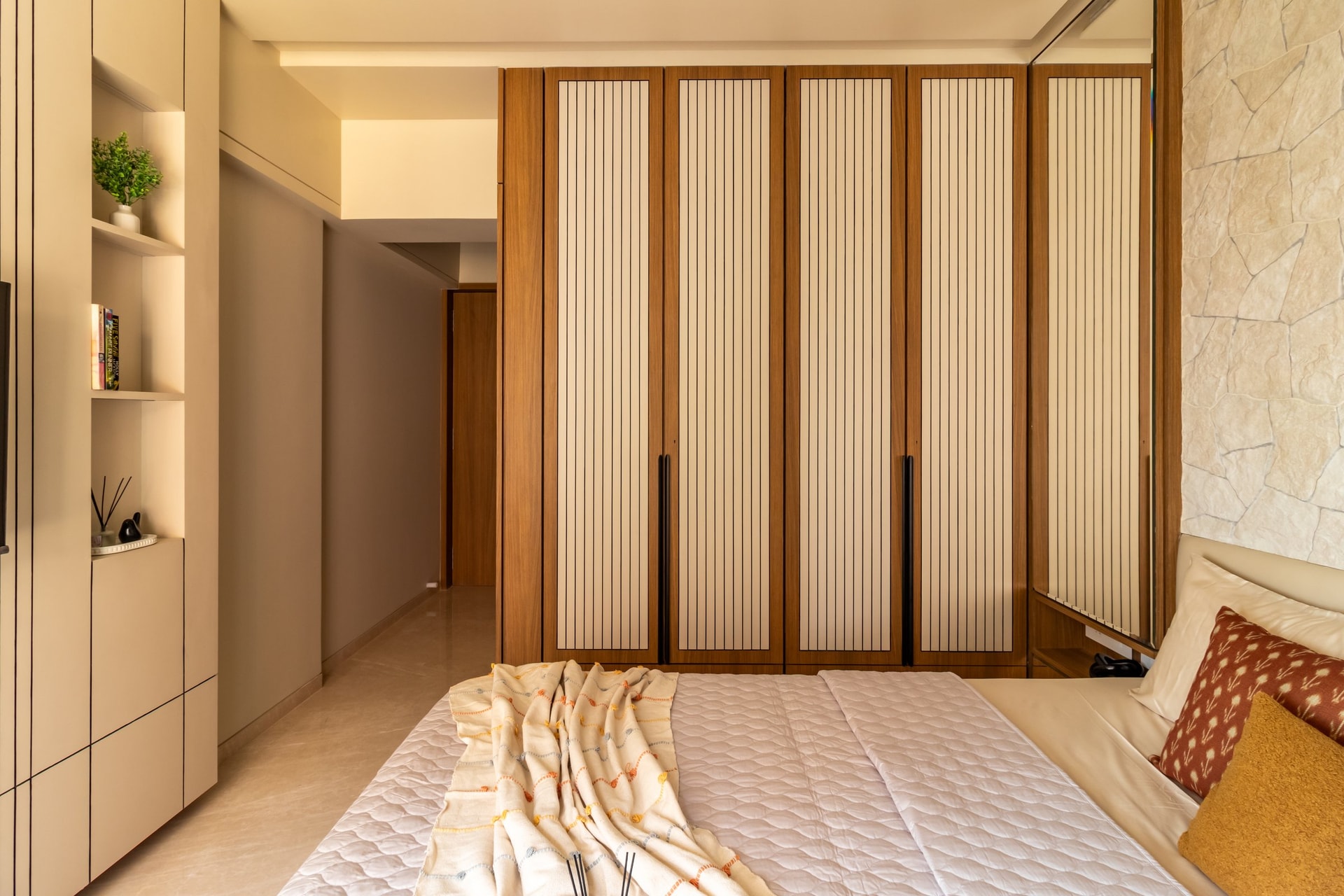 The wardrobe wall of the second bedroom, articulated in warm wood frames and vertically slatted panelled inserts