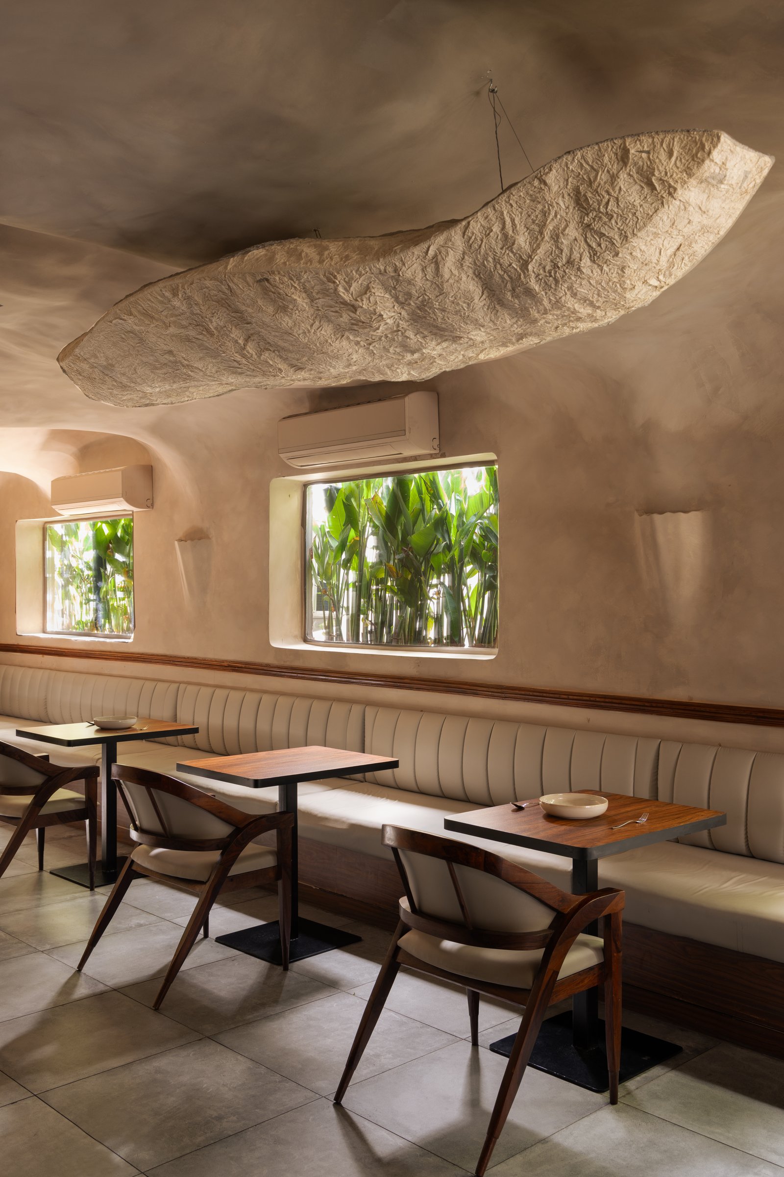 The main dining volume, with its cloud-like sculptural pendant hovering above the banquette